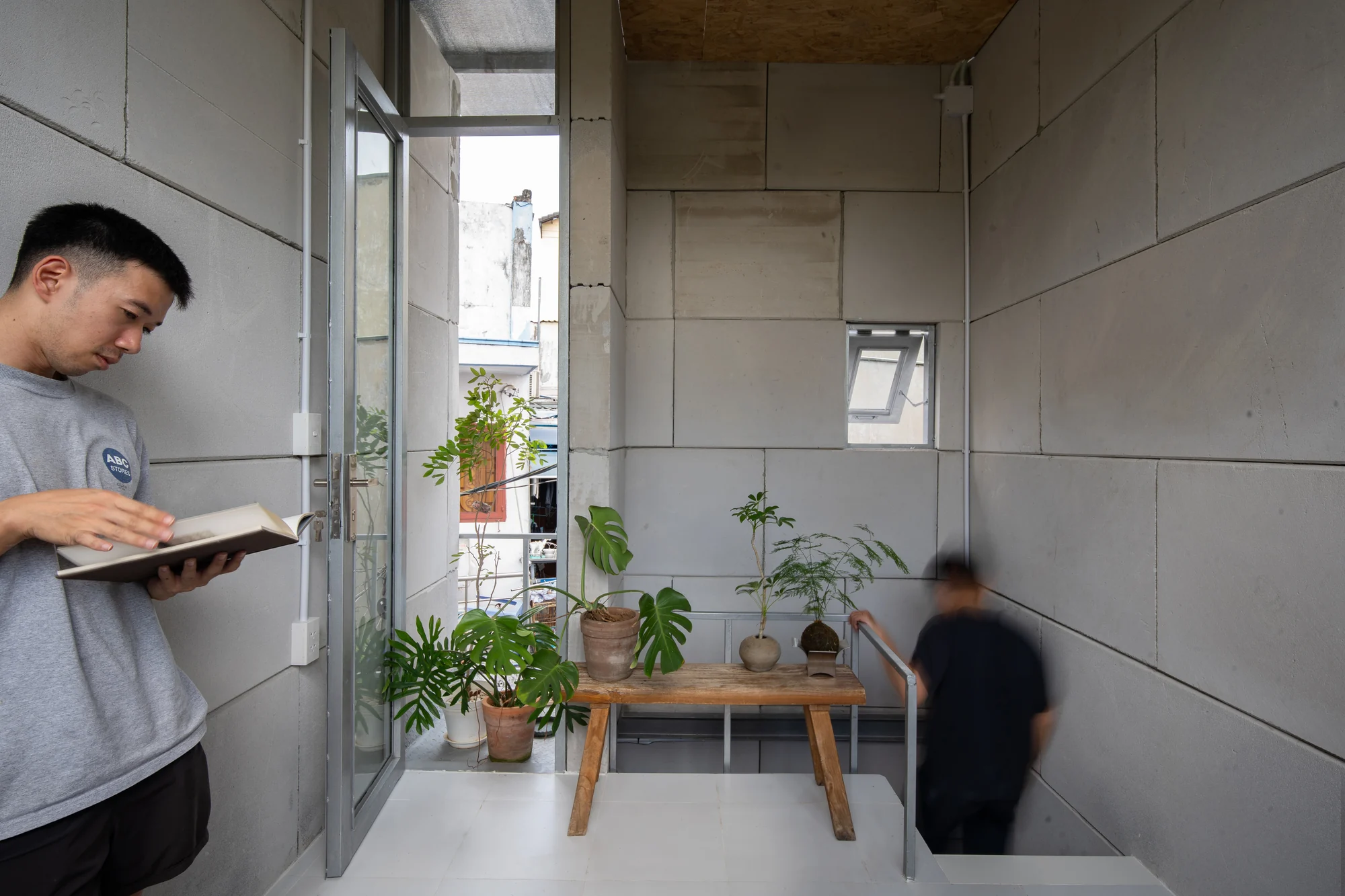 11M2 HOUSE by scale50, photographed by Nguyen Manh Toan — Street view of the slender three-storey volume rising behind a tangle of overhead cables in District 4.