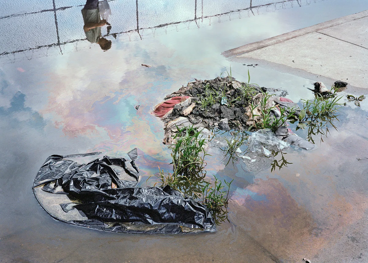 Christopher Postlewaite by Christopher Postlewaite, photographed by Christopher Postlewaite — The transcendent puddle near Postlewaite's South Philadelphia home, an oil-slick rainbow pooling over weeds, a torn black trash bag and an upside-down…