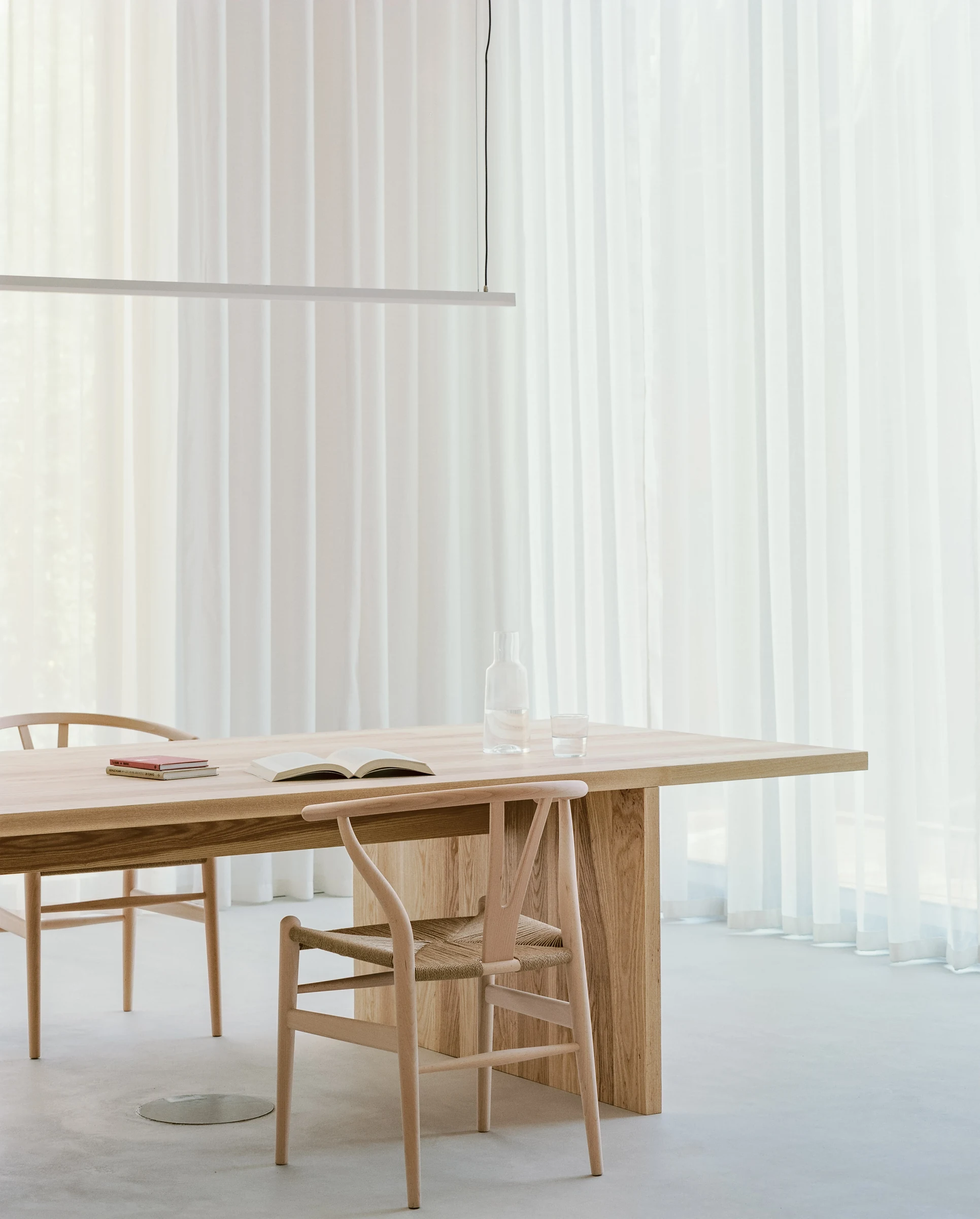 Cherry Orchard by Actual Office, photographed by Nick Dearden — Detail of a built-in aperture in the oak joinery wall: a deep square opening glazed with translucent panel acts as a small interior window, with a low bench under it carrying a stoneware…