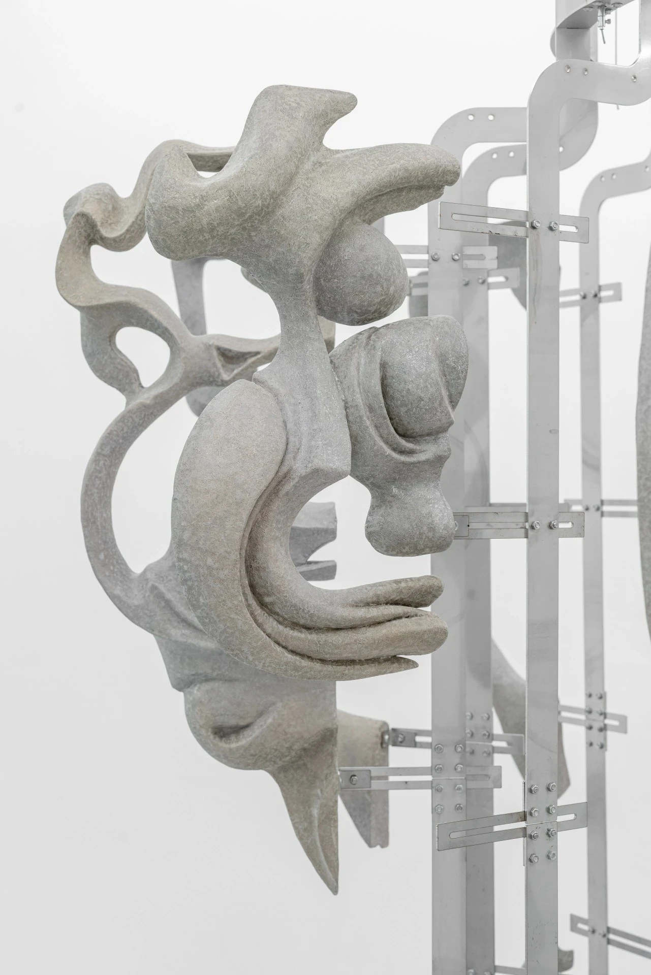 Double Star by Paola Siri Renard, photographed by Dirk Tacke — a tight view of swelling sandblasted forms where muscled anatomy meets whiplash Art Nouveau coils, bulbous joints set against bright steel brackets and bolts.