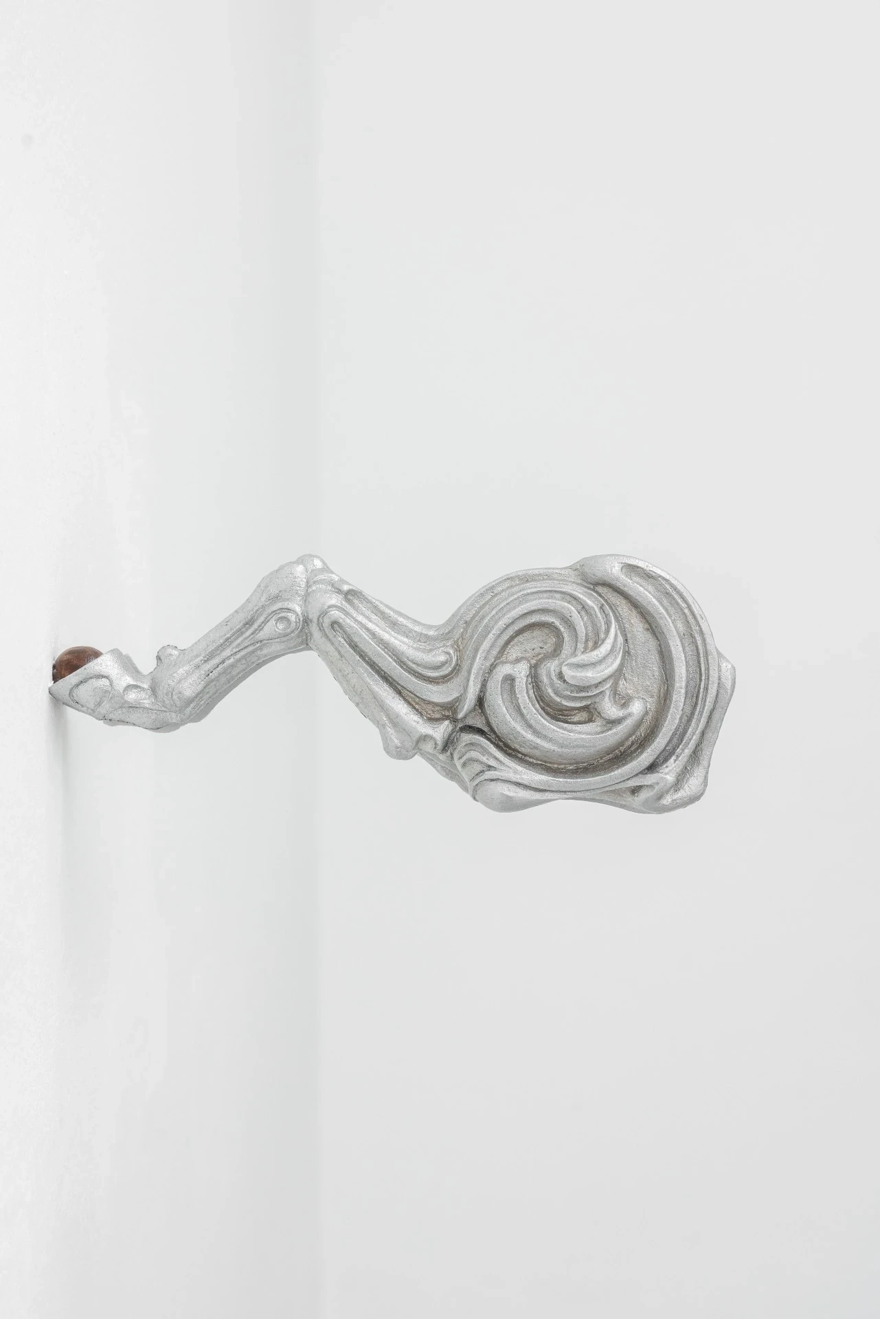 Double Star by Paola Siri Renard, photographed by Dirk Tacke — a sandblasted fragment fusing skeletal bone with a tight Art Nouveau spiral, the ornament spinning out from a thin anatomical stem.