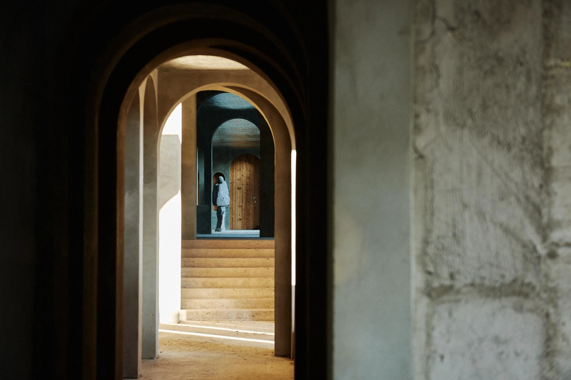Xavier Corberó House and Studio by Xavier Corberó, photographed by Daniel Schäfer — Low upward view of concrete towers, an empty rectangular portal frame set beside grids of small arches cut against the sky.