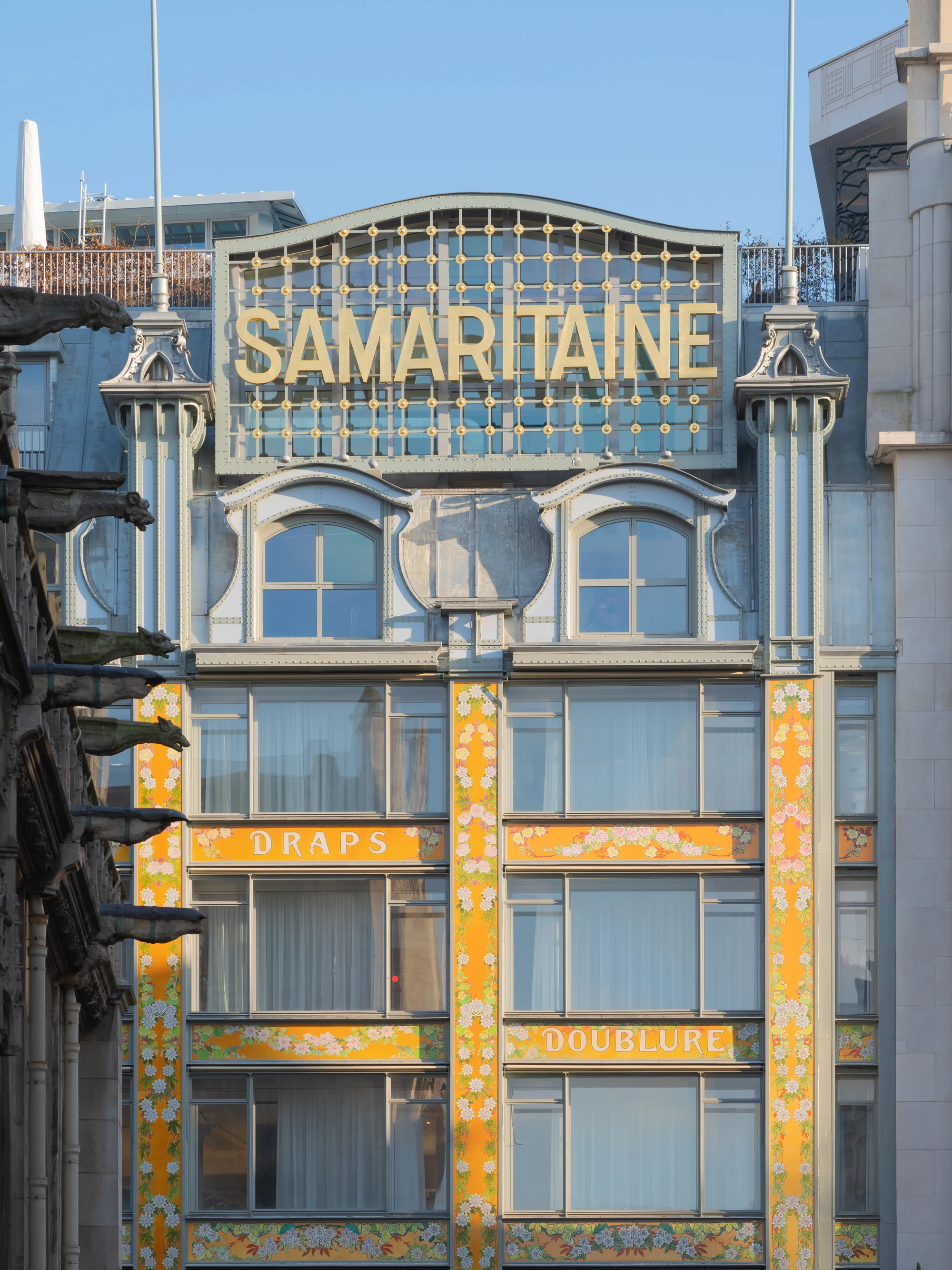 La Samaritaine by SANAA, photographed by Jared Chulski — The gilt SAMARITAINE lettering and yellow enamel panels of the historic facade, DRAPS and DOUBLURE spelled out in flowers.