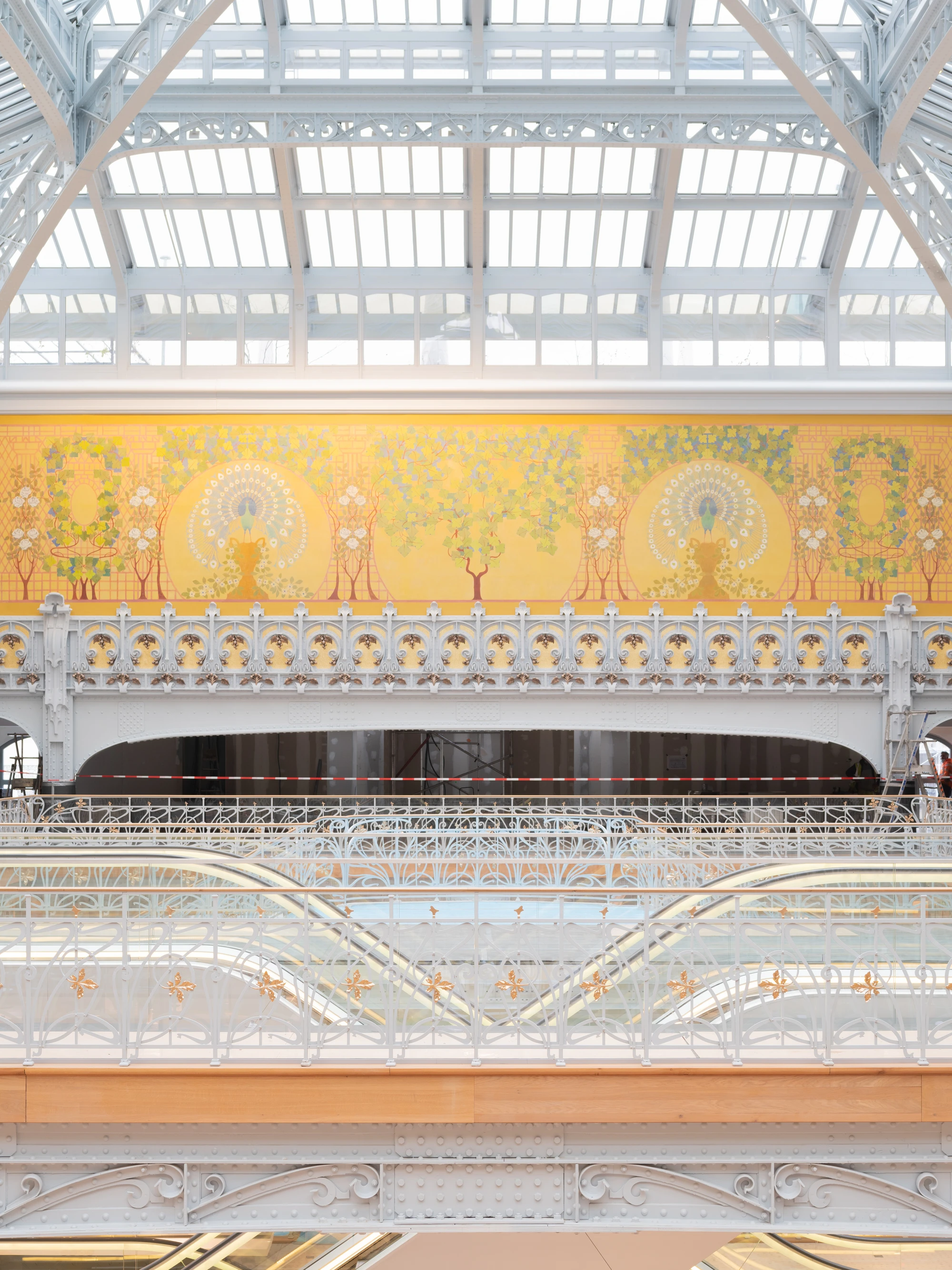 La Samaritaine by SANAA, photographed by Jared Chulski — The peacock mural and glazed roof seen over the sinuous ironwork of the upper galleries.