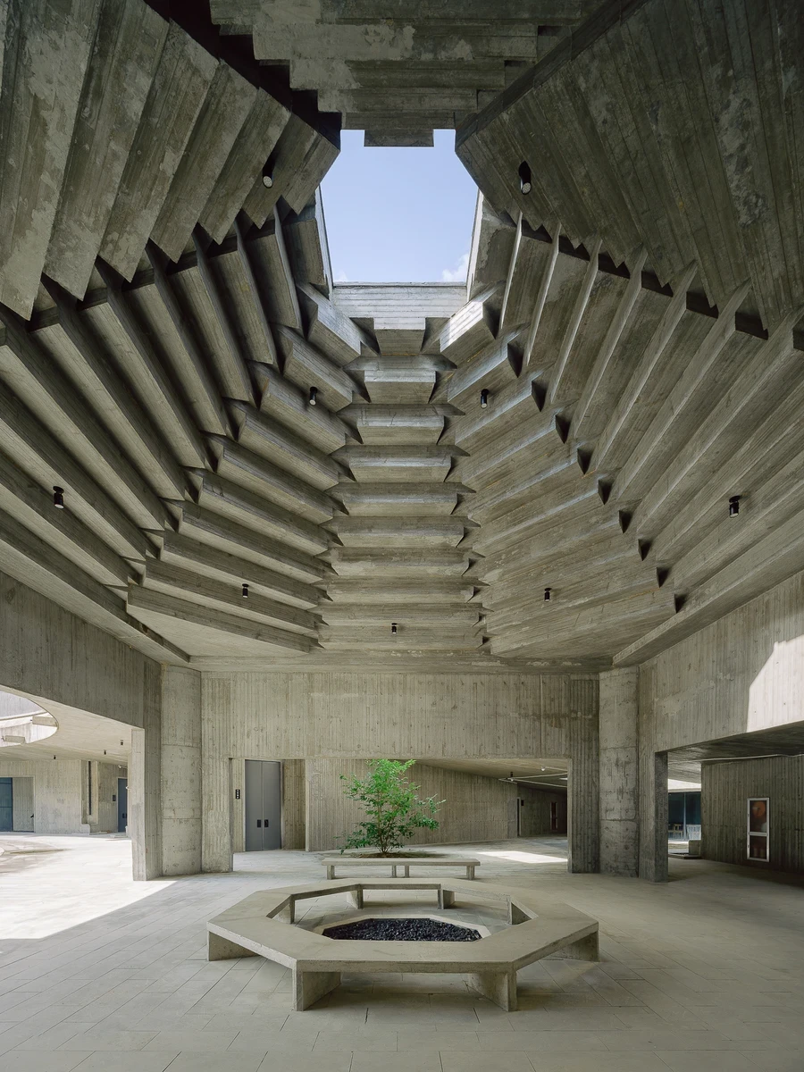 Suichang Funerary Complex by Untitled Architects — Zhejiang, China: The Suichang Funerary Complex by Untitled Architects sinks a set of board-formed concrete halls into a wooded valley in Zhejiang, China, where a coffered ceiling steps upward toward a sin