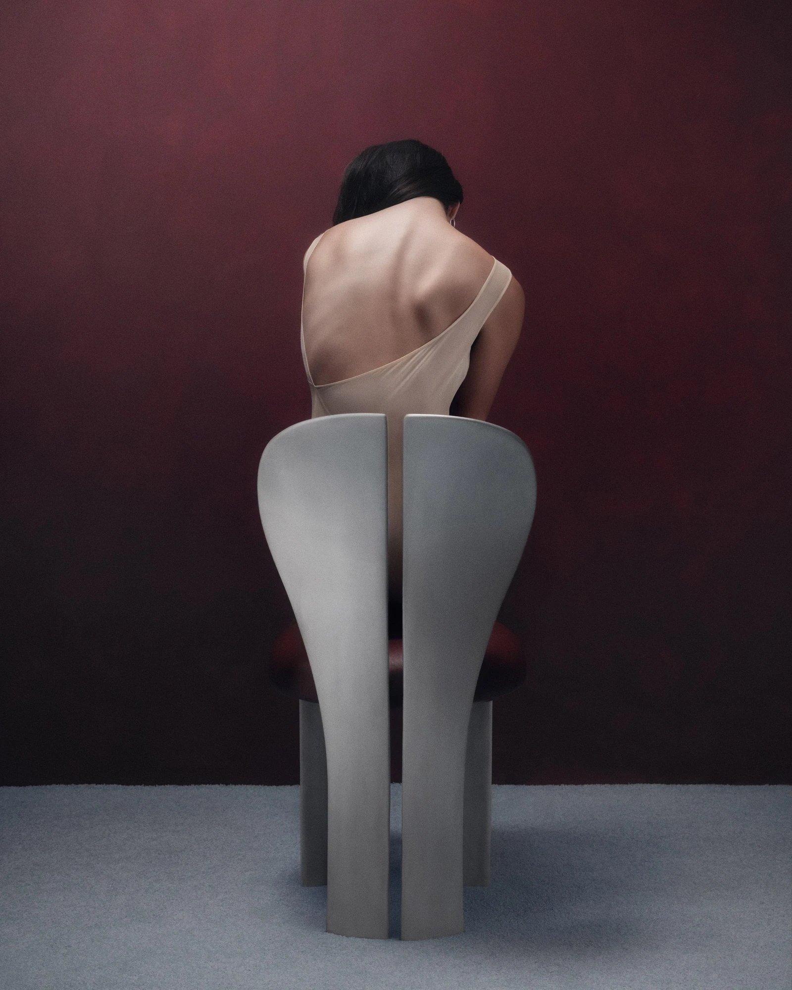Lilium Chair by Studio NRG — the rear view reveals the centre seam splitting the two petal panels and the fluted concave legs.