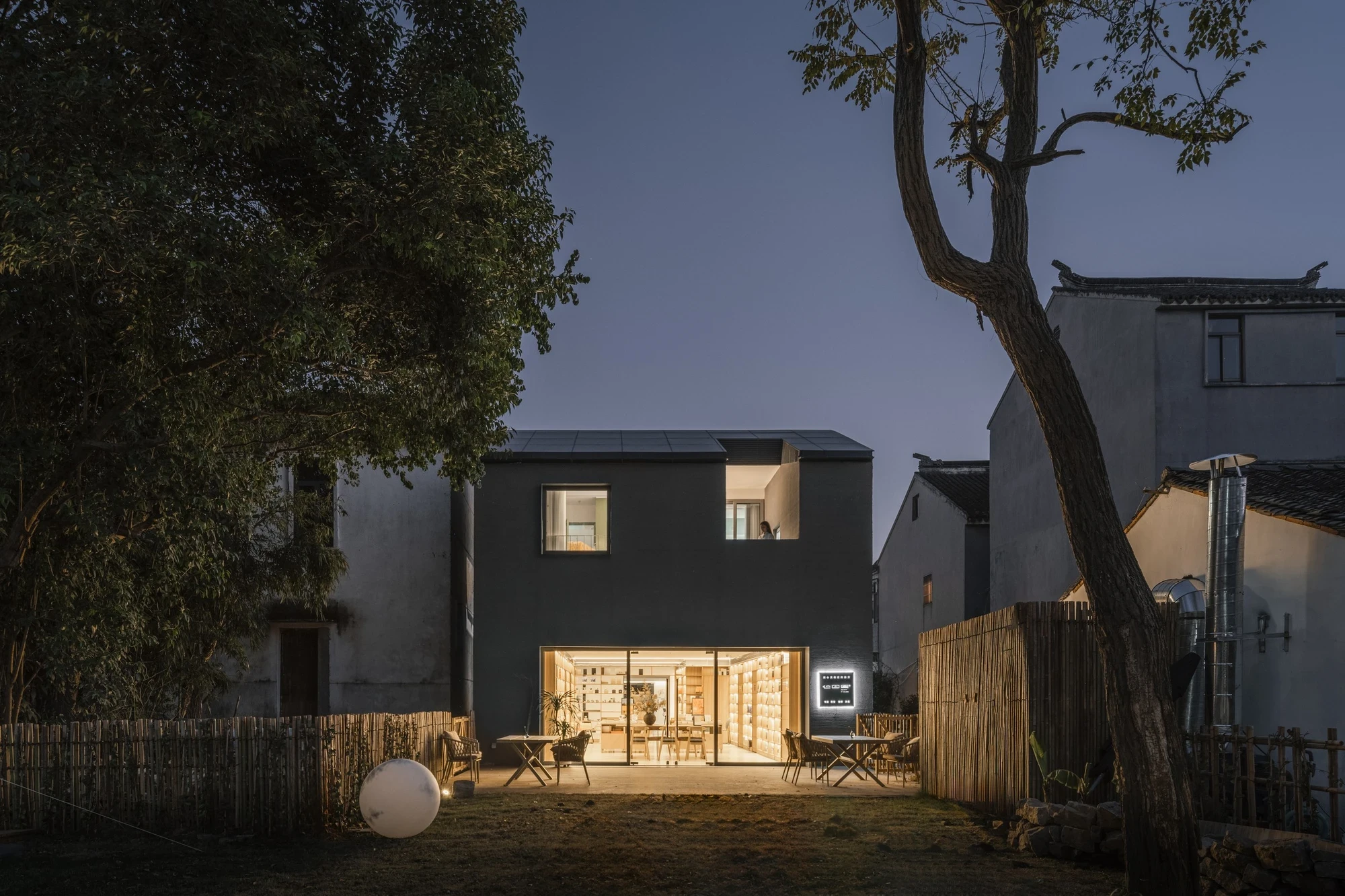 Heart Fields by Wutopia Lab, photographed by CreatAR Images — a lone figure stands against the fine-textured black gable wall as deep-set square windows catch the light.