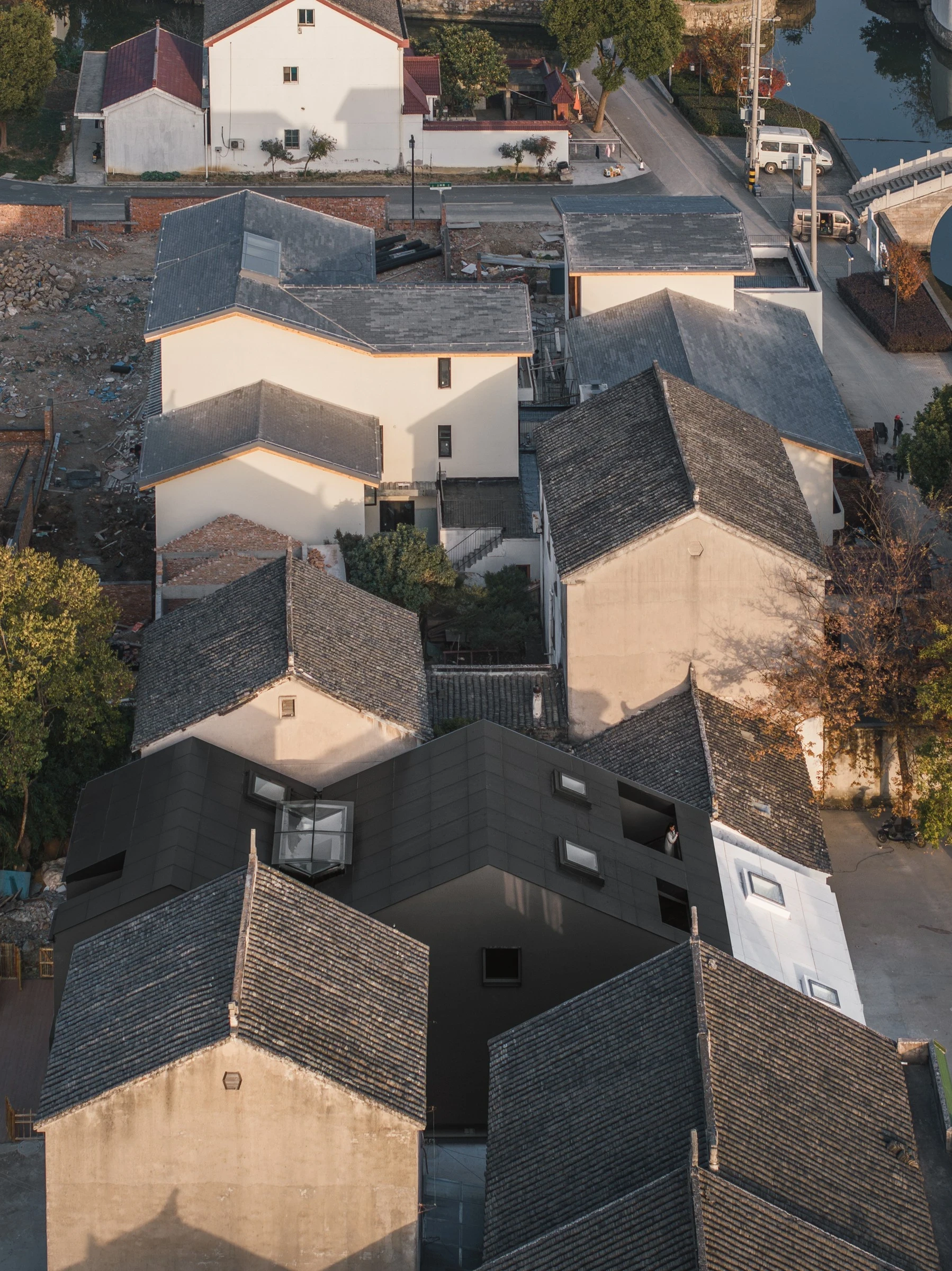 Heart Fields by Wutopia Lab, photographed by CreatAR Images — seen from the air at dusk, the lit compound sits among village houses and open farmland beyond.