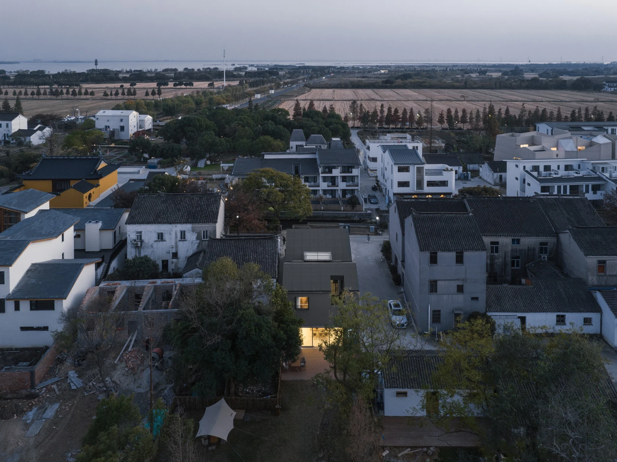 Heart Fields by Wutopia Lab, photographed by CreatAR Images — an aerial view sets the black roof and white house against the grey tiled roofs of neighbouring courtyard houses.