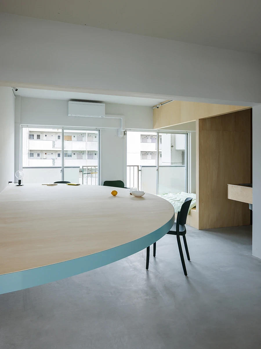 A Large Semicircle That Holds Everyday Life by Tato Architects, Kyoto, Japan: a 3.6-metre semicircular table reorganizes a vacant municipal apartment.