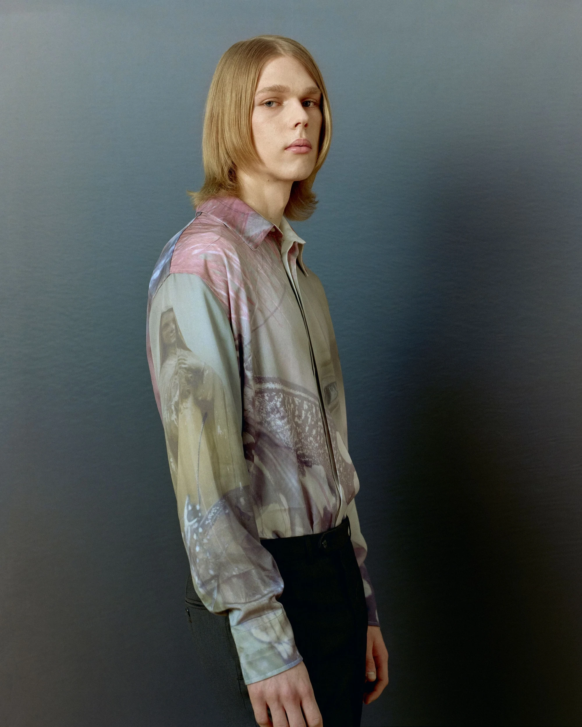 Unofficial Dnipro by Eugenia Skvarska and Kalpesh Lathigra — Studio portrait of a young man in a printed shirt against a grey backdrop.
