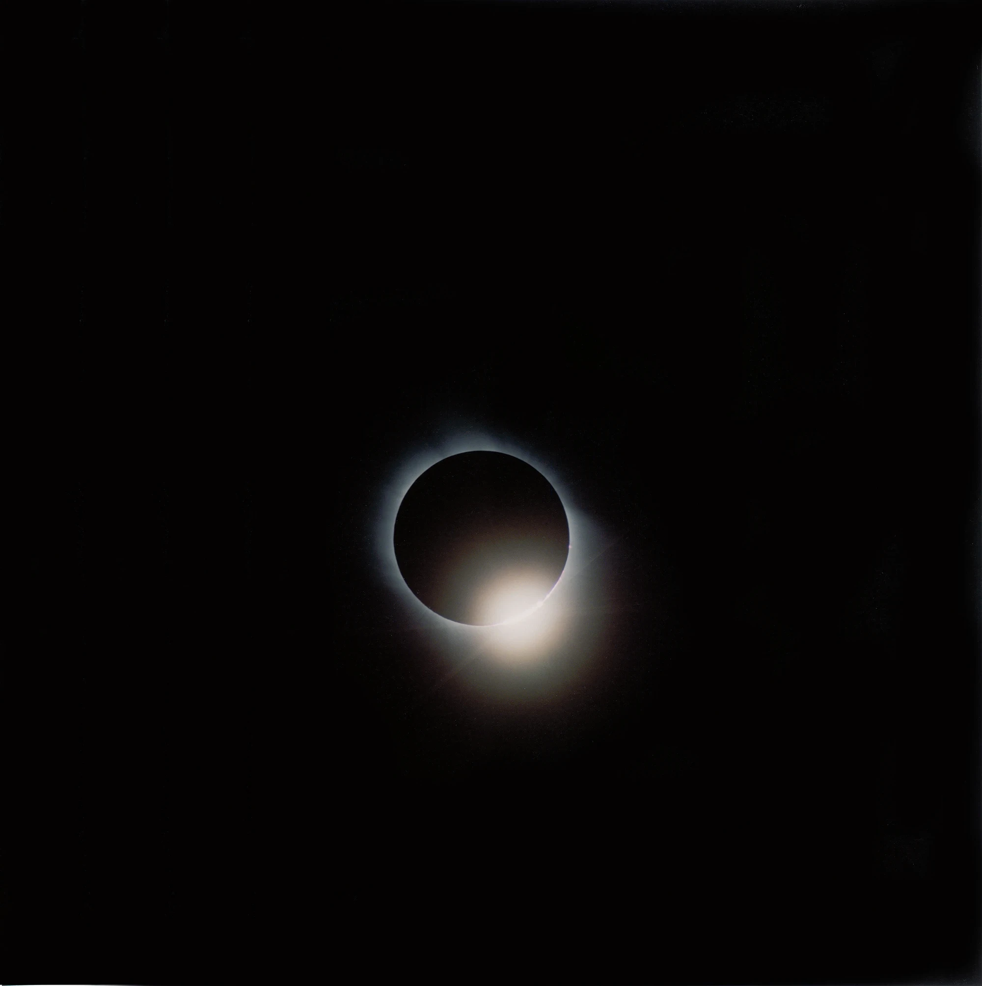 Illuminance by Rinko Kawauchi -- A solar eclipse's corona glows faintly around a darkened sun