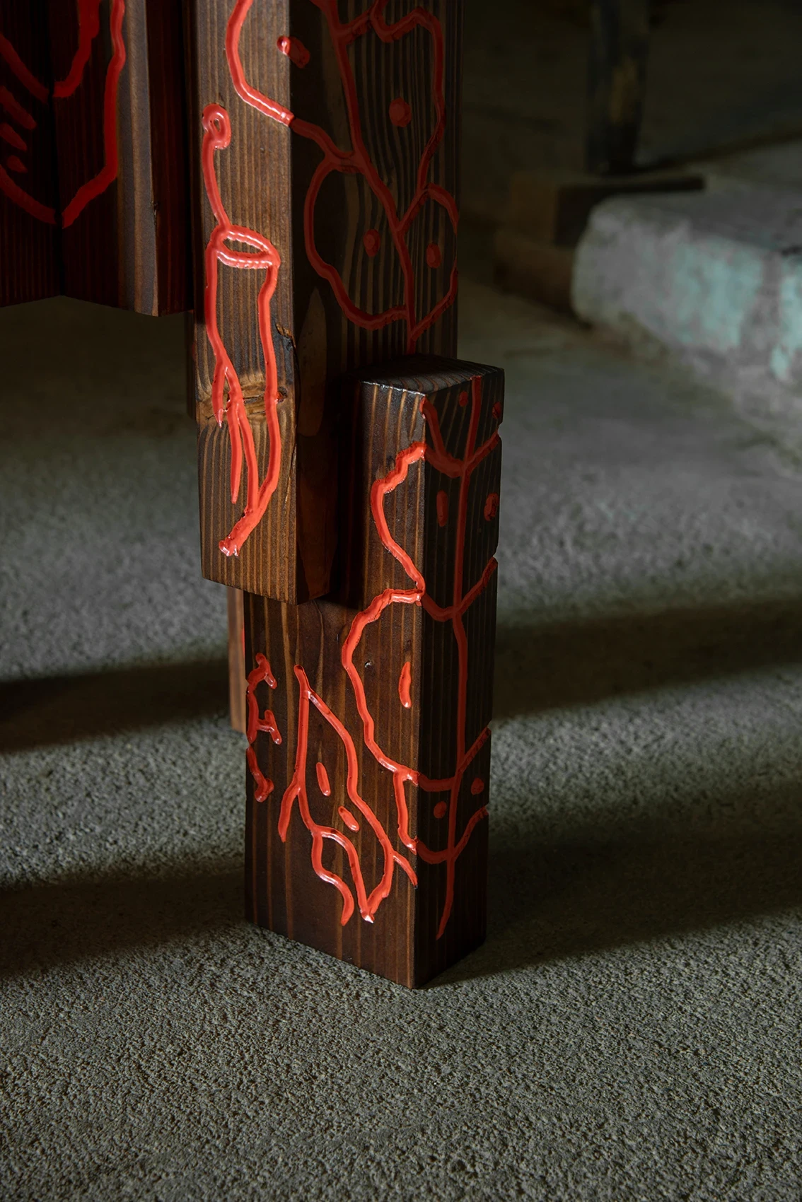 Les Rhizopodes by Barreau Charbonnet — Close view of two block legs, cellular veins and membranes carved and flooded with glossy red pigment