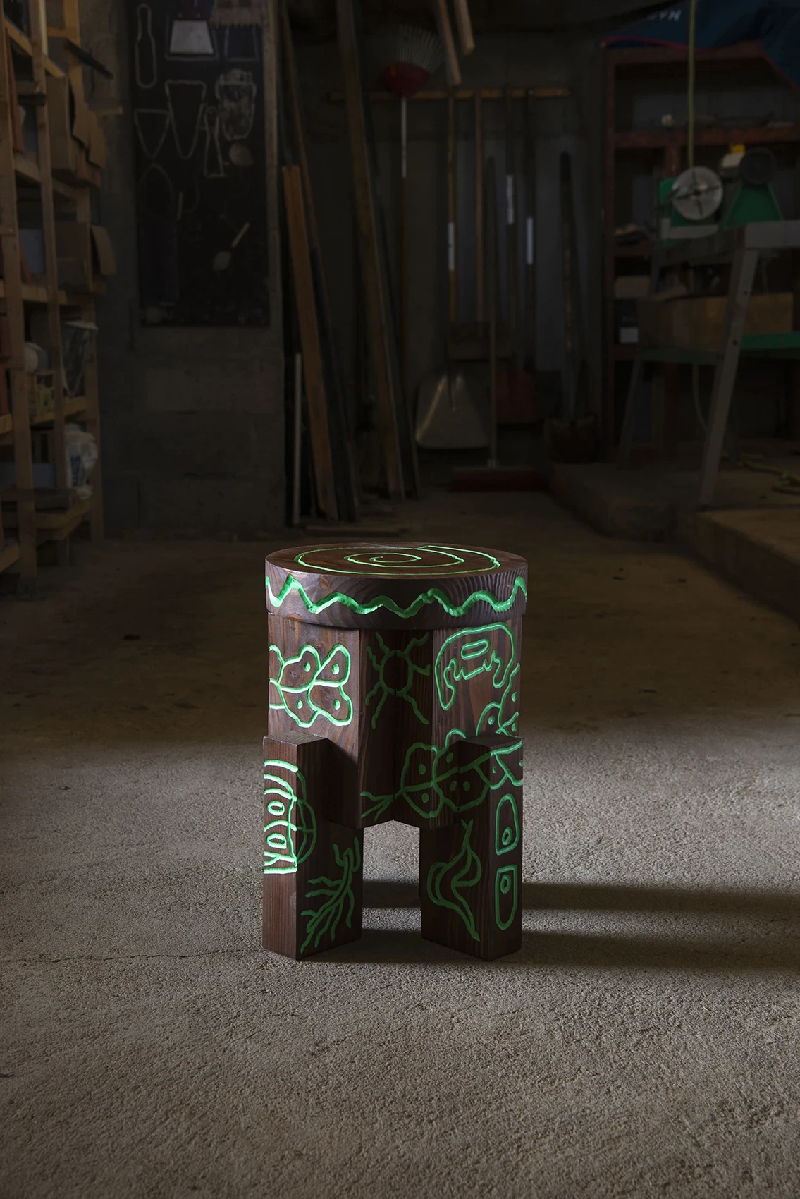 Les Rhizopodes by Barreau Charbonnet — A round green-lined stool on the workshop floor, a spiral crowning the seat above cellular legs