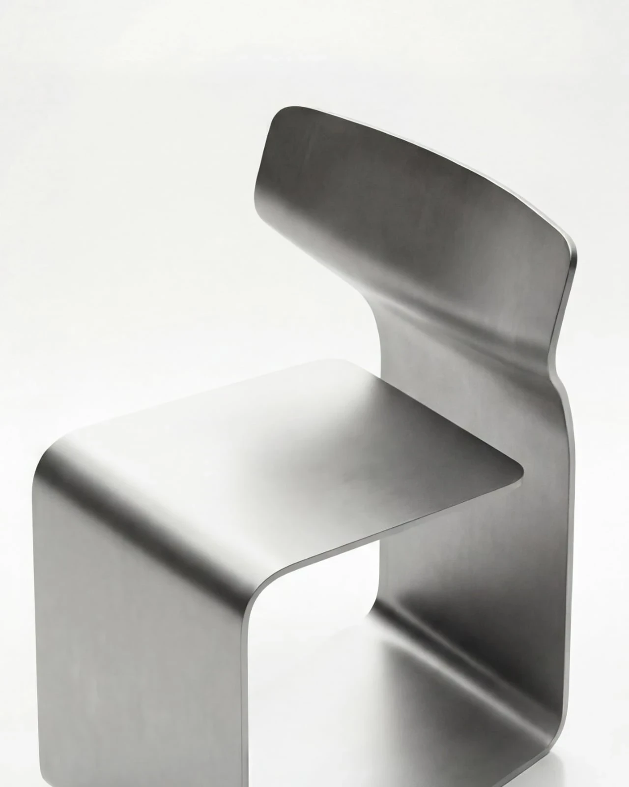 ZERO Chair by Davide Bozzo — A close view of the seat and the flaring backrest, the single sheet visibly thin at its edge as it bends from horizontal plane to vertical curl
