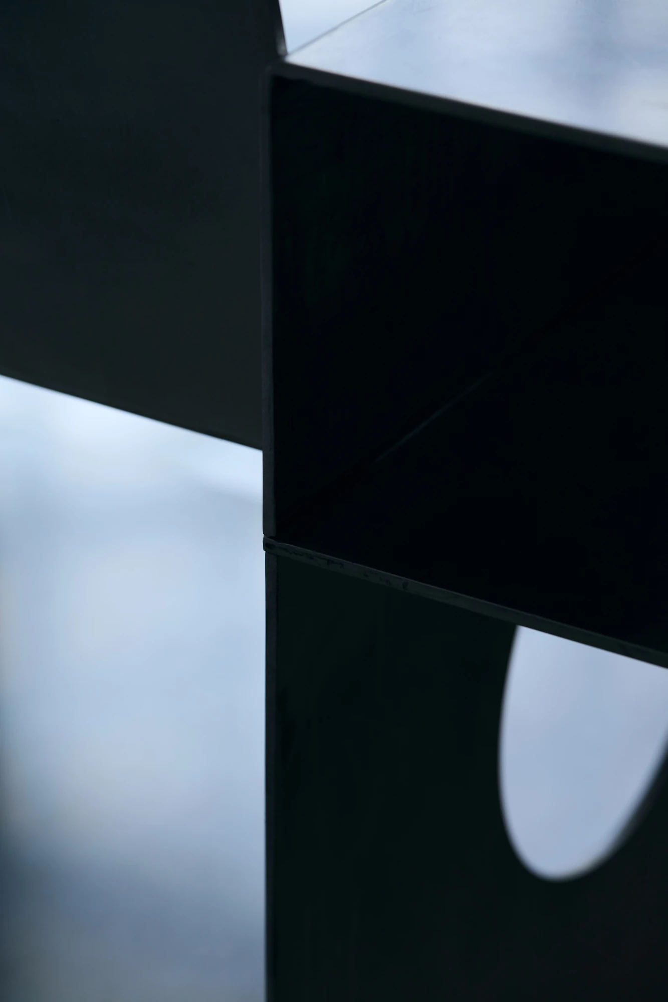 010 Aluminium Lounge Chair by OFAA, photographed by @spaceblank, @aura.photography — Tight crop on a folded aluminium edge set against a pale, out of focus background.