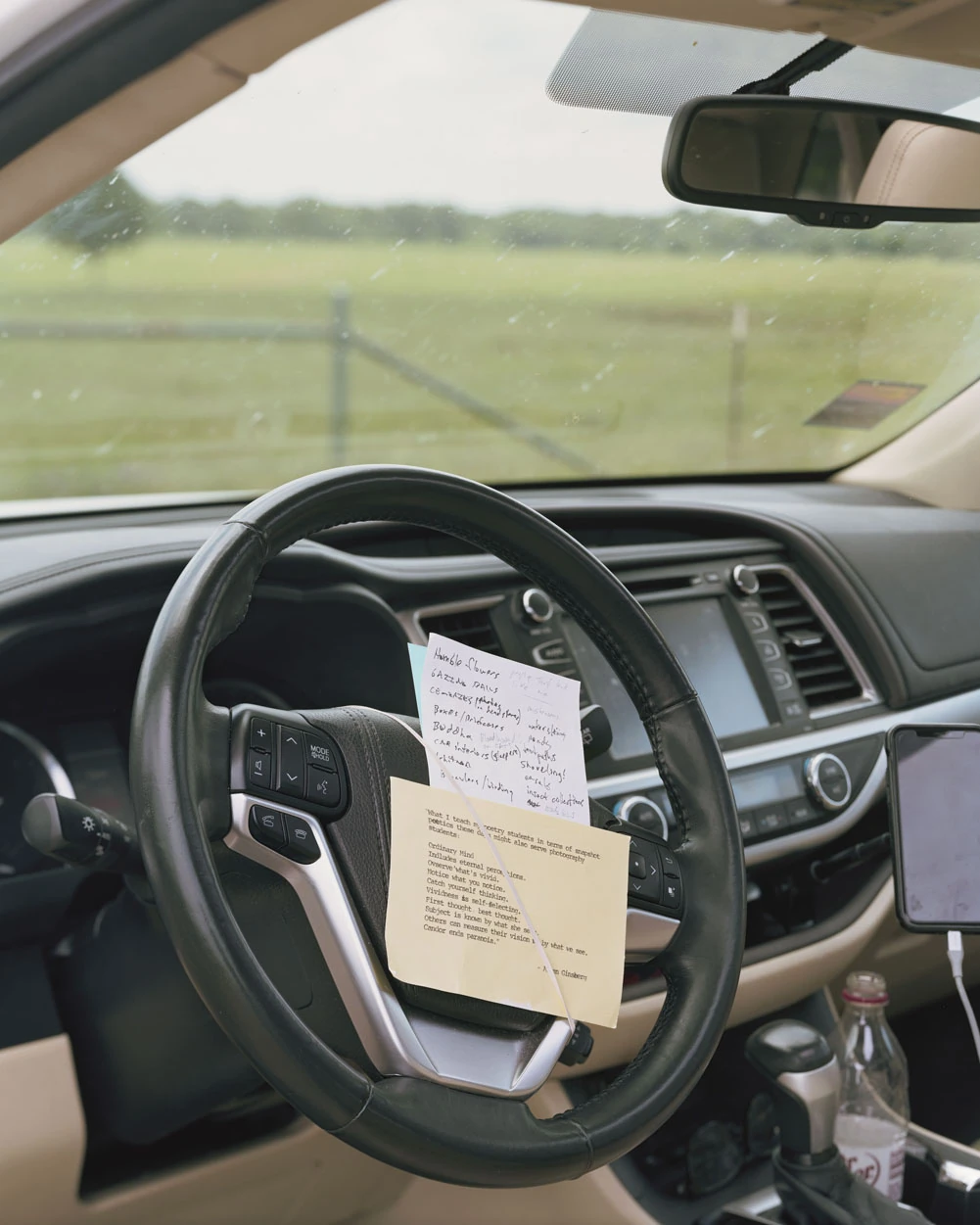A Pound of Pictures by Alec Soth, photographed by Alec Soth — A handwritten list and a typed page of Allen Ginsberg's notes on snapshot poetics clipped to the steering wheel of a parked car, from A Pound of Pictures by Alec Soth.