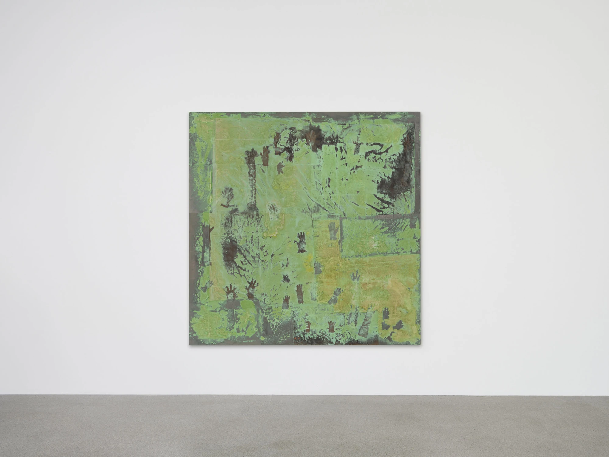 Dolls' Theater by Mimosa Echard, photographed by Julien Gremaud, Annik Wetter — A large square tableau in oxidised green, scattered with dark handprints and glove marks, hung alone on a white wall.