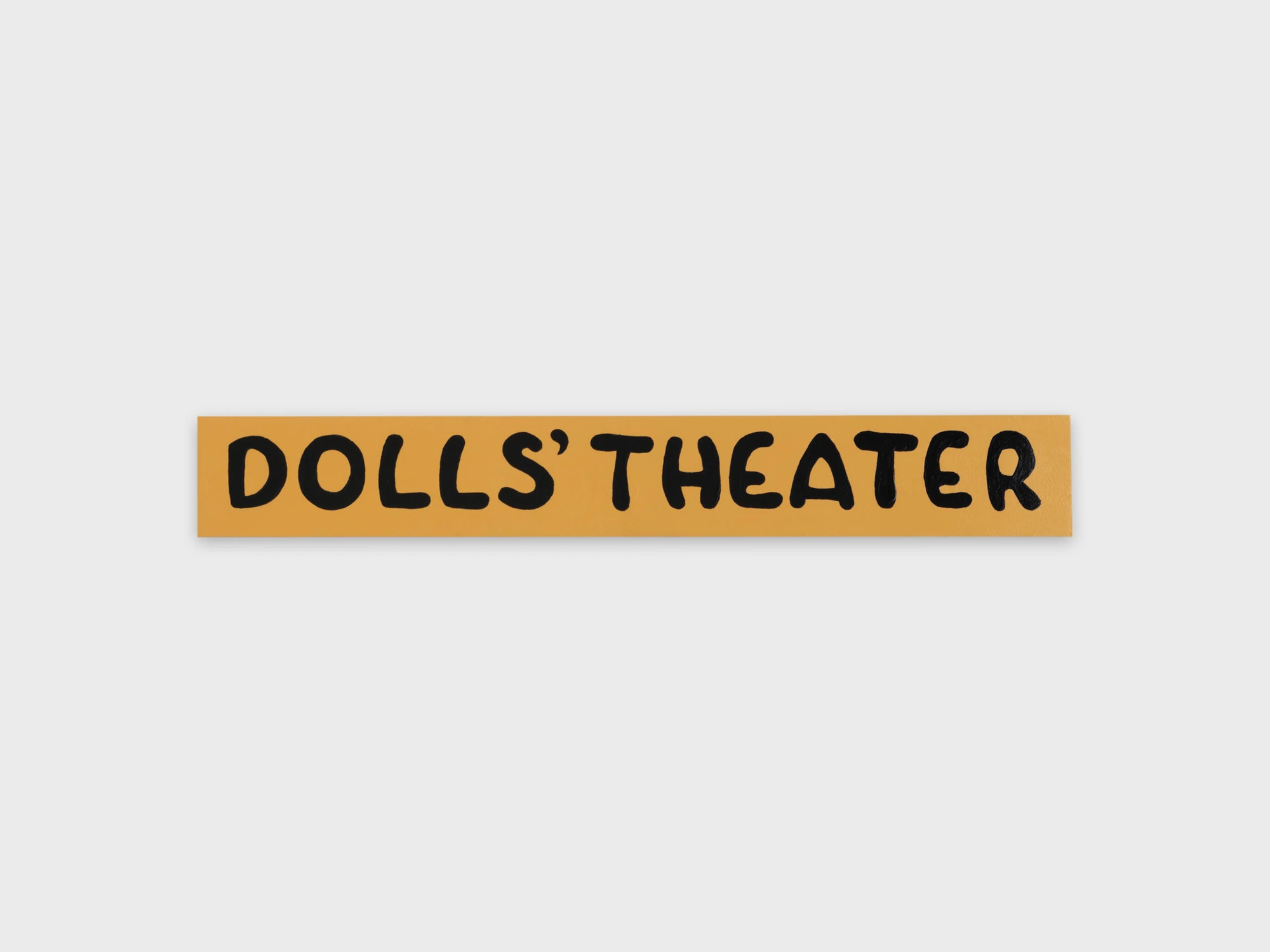Dolls' Theater by Mimosa Echard, photographed by Julien Gremaud, Annik Wetter — A hand-painted ochre sign reading DOLLS' THEATER in wobbling black capitals on a white wall.
