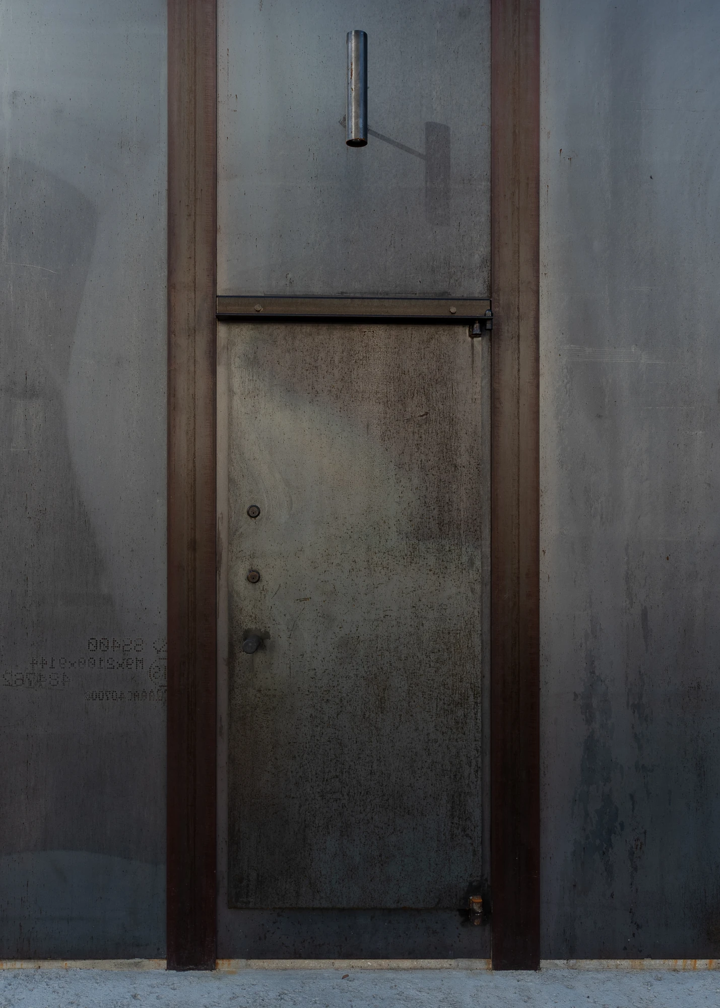 Shironishi Office by Tomoaki Uno Architects, photographed by Nathanael Bennett — The entrance door, flush plate set between two flanges, a cut steel spout above it and mill stencils still legible on the panel to the left.