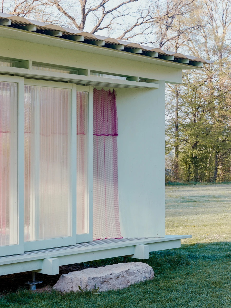Pavilion of the Sliding Doors by Piertzovanis Toews, photographed by Federico Farinatti — A magenta mesh curtain hangs out past the sliding panels and over the edge of the deck.