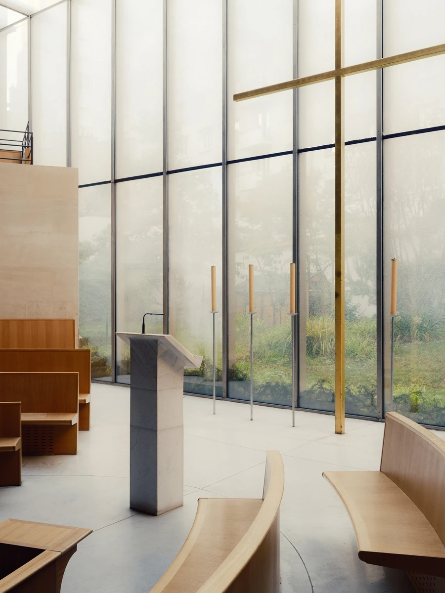 Église Saint-François de Molitor by Corinne Callies and Jean-Marie Duthilleul — A pale grey stone ambo stands alone on the polished floor in front of the glazed wall, its slabs meeting in open mitred joints.