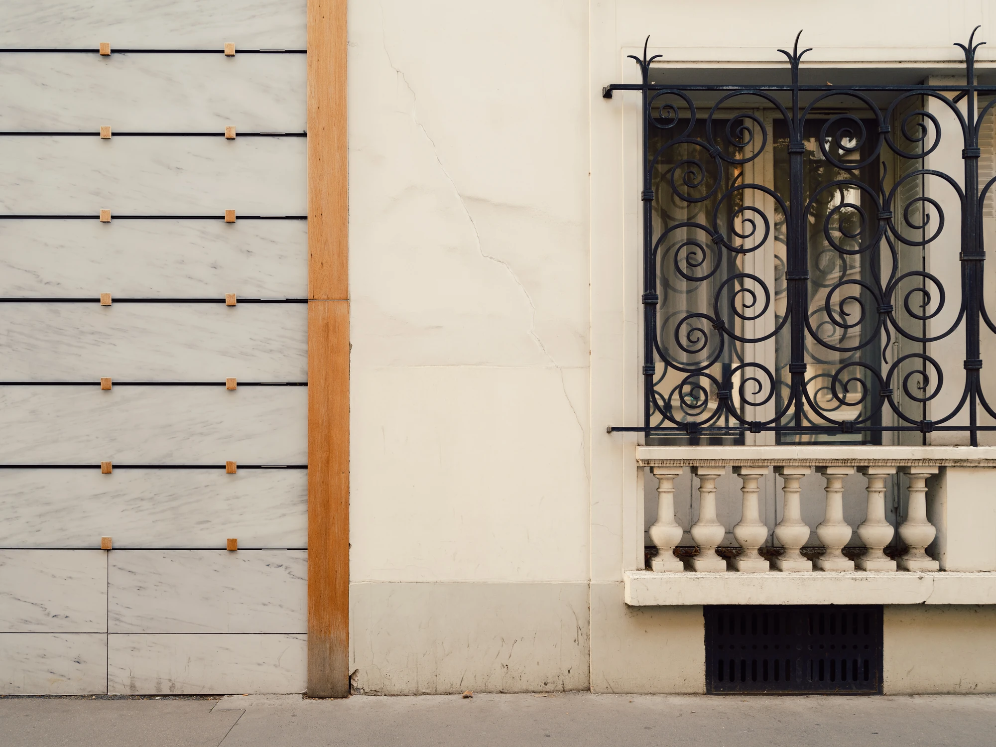 Église Saint-François de Molitor by Corinne Callies and Jean-Marie Duthilleul — The marble cladding meets the render of the neighbouring building, where a wrought iron balcony and stone balustrade mark the older street wall.