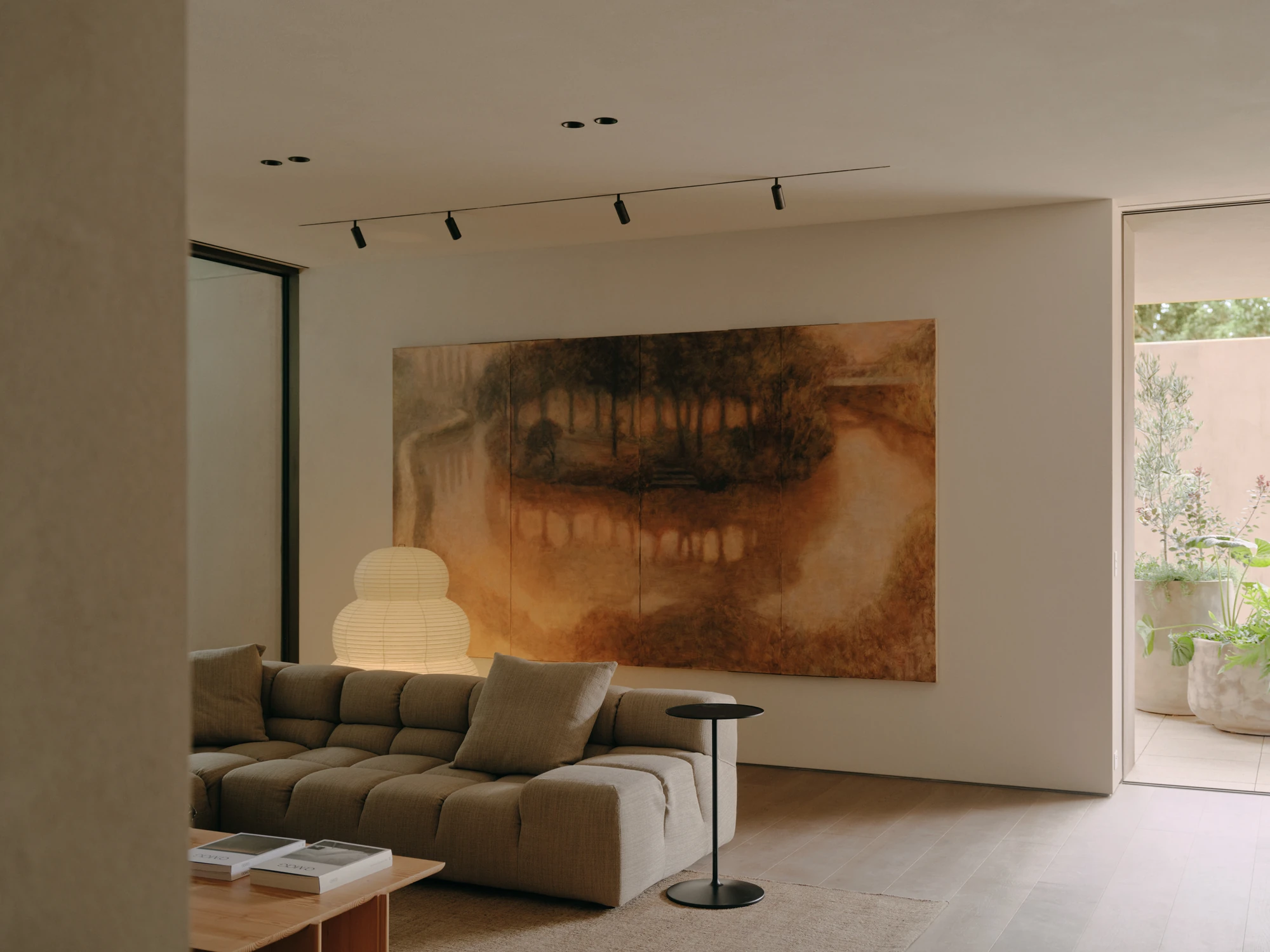 49 Walsh Street by MORQ, photographed by Tom Ross — A large earth-toned landscape painting spans the living room wall, lit from a track above.