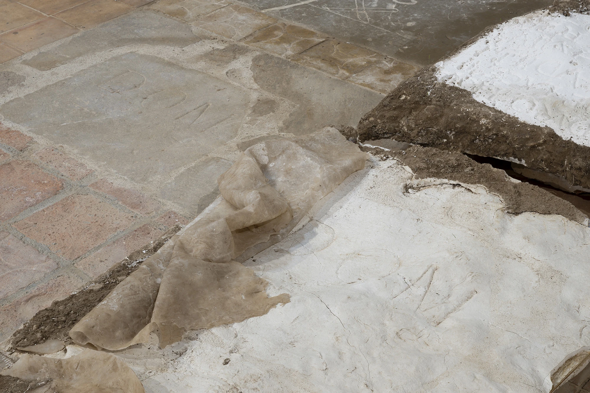 KIN TOO by Spiritvessel, photographed by Roberto Ruiz — Close view of Monia Ben Hamouda's Ghost, translucent silicone folded over a bed of white plaster and soil across the church floor.