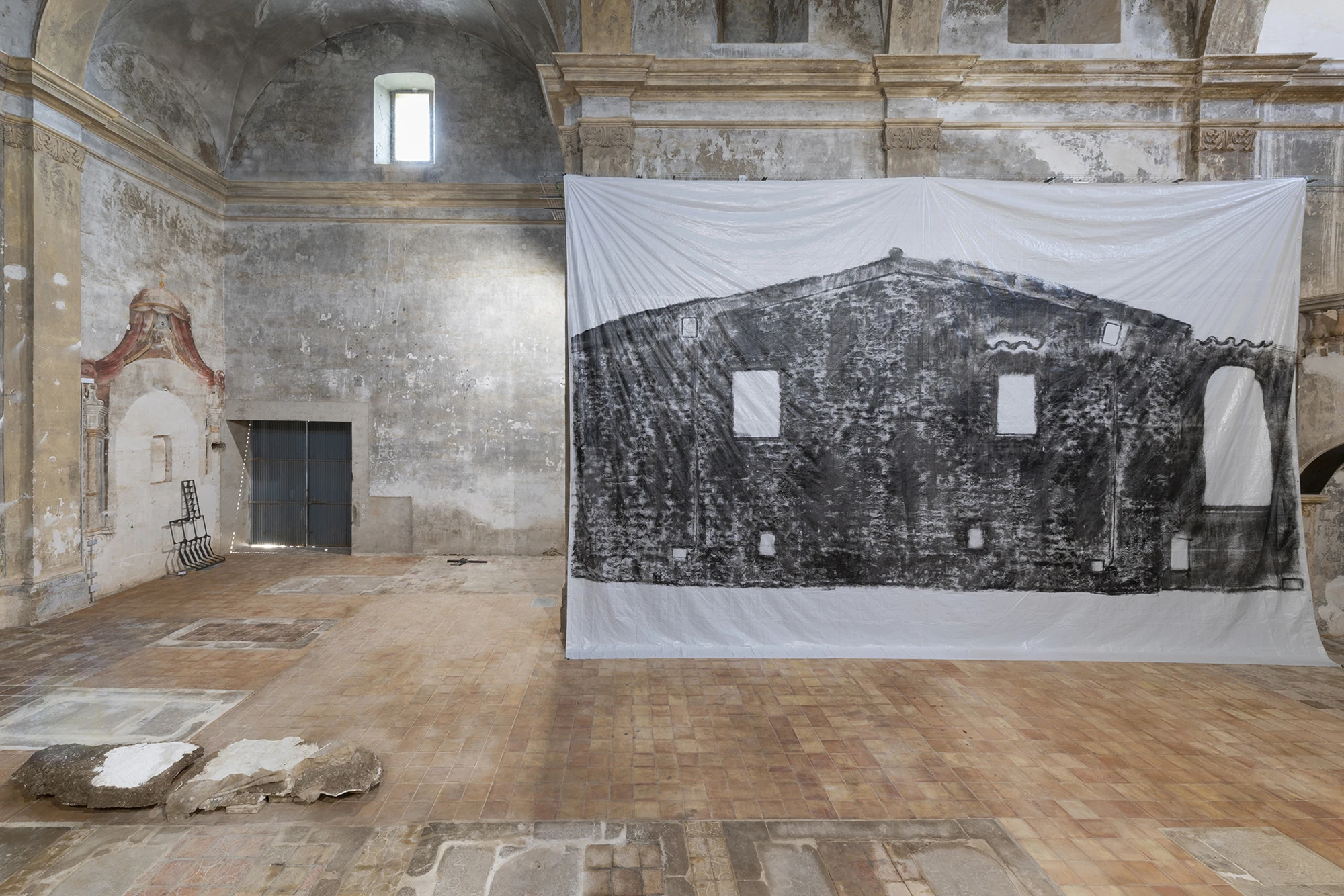 KIN TOO by Spiritvessel, photographed by Roberto Ruiz — Andrew Birk's Floating House, a building's facade impressed in black across a large hanging canvas, with Jordi Mitjà's steel grille visible in the nave beyond.