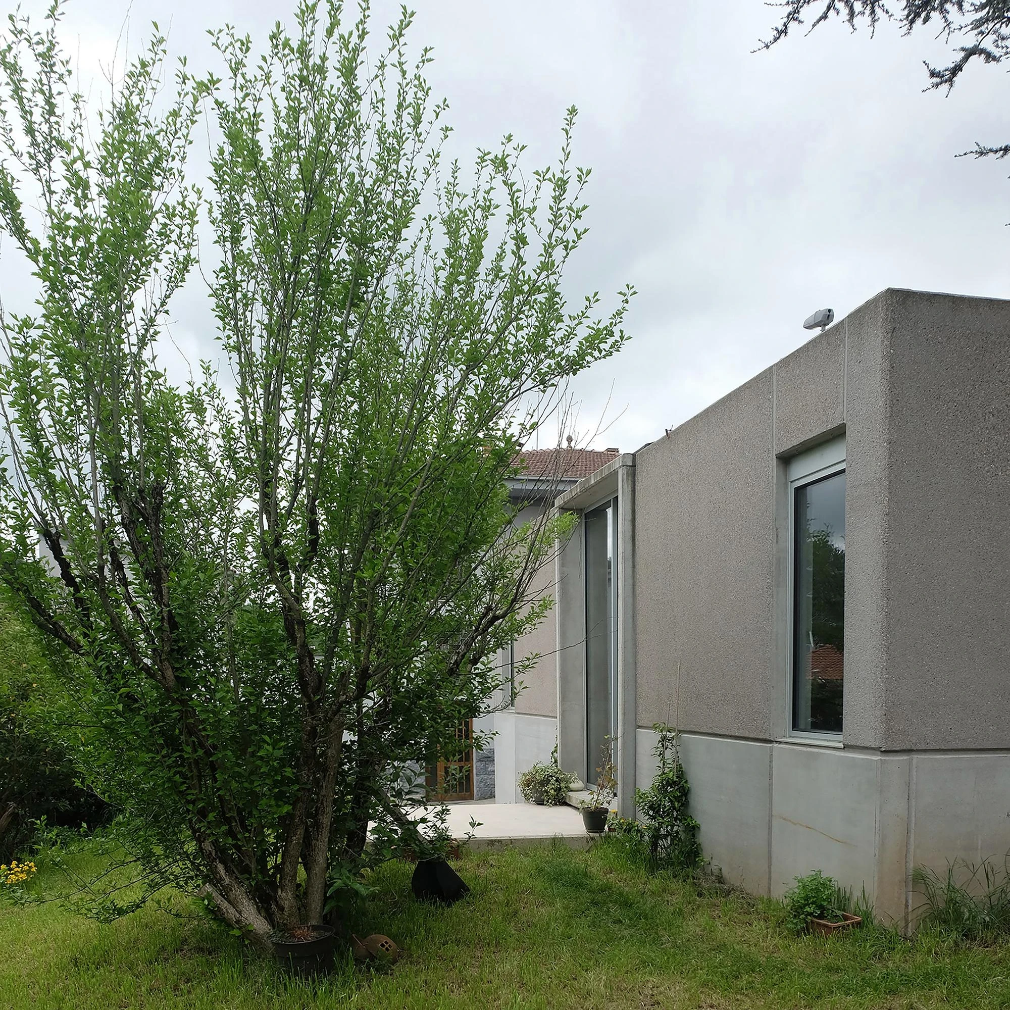Prefab Pavilion Facing a Centuries-Old Cedar by Jordi Hidalgo Tané, photographed by Pep Sau, Jordi Hidalgo — Exterior view of a corner junction of the prefabricated concrete volume beside the garden.