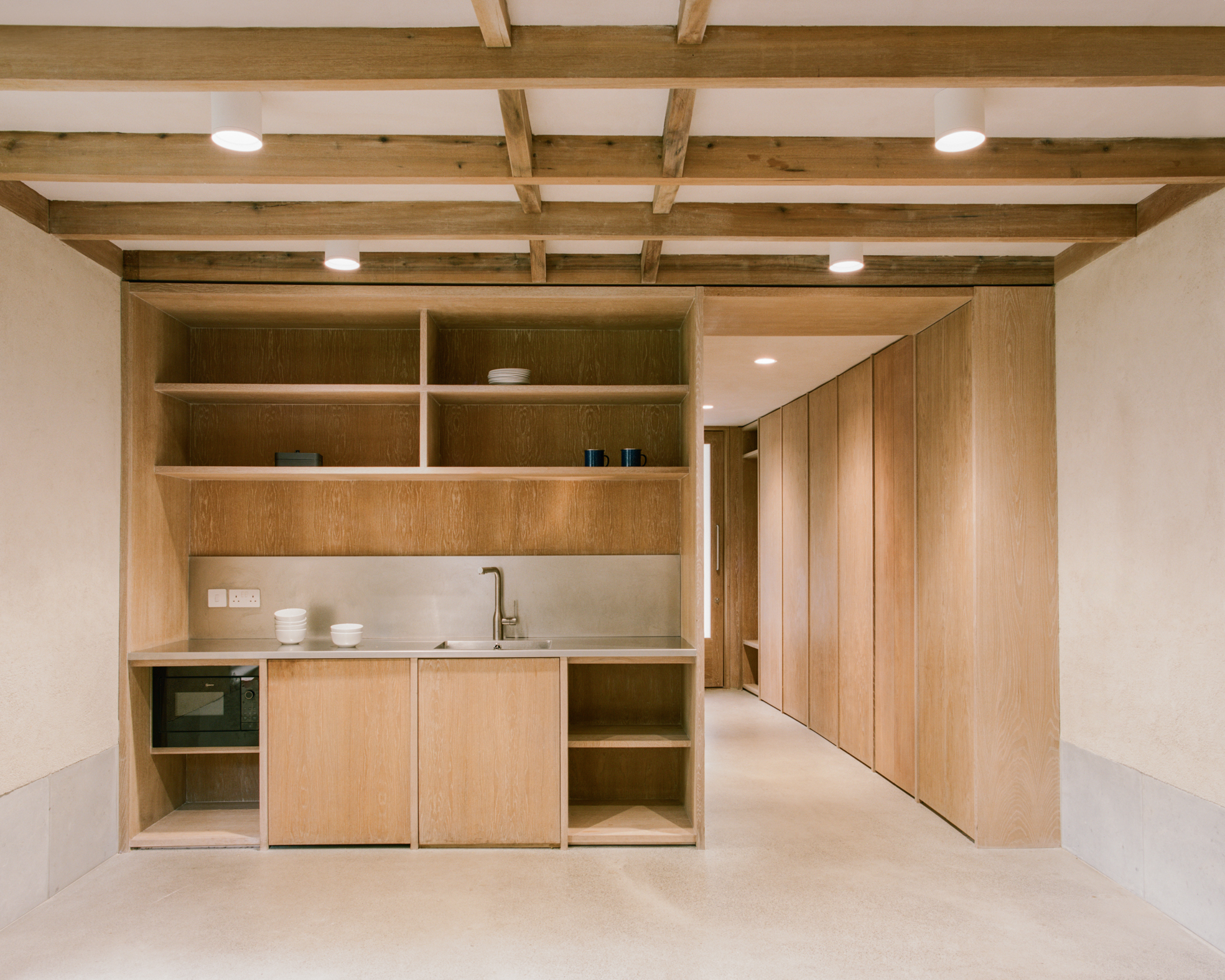 Finsbury Circus Parks Office by Studio Weave, photographed by Lorenzo Zandri — The kitchenette pairs a stainless steel counter with oak shelving and storage for the City Gardens team's tools and equipment.