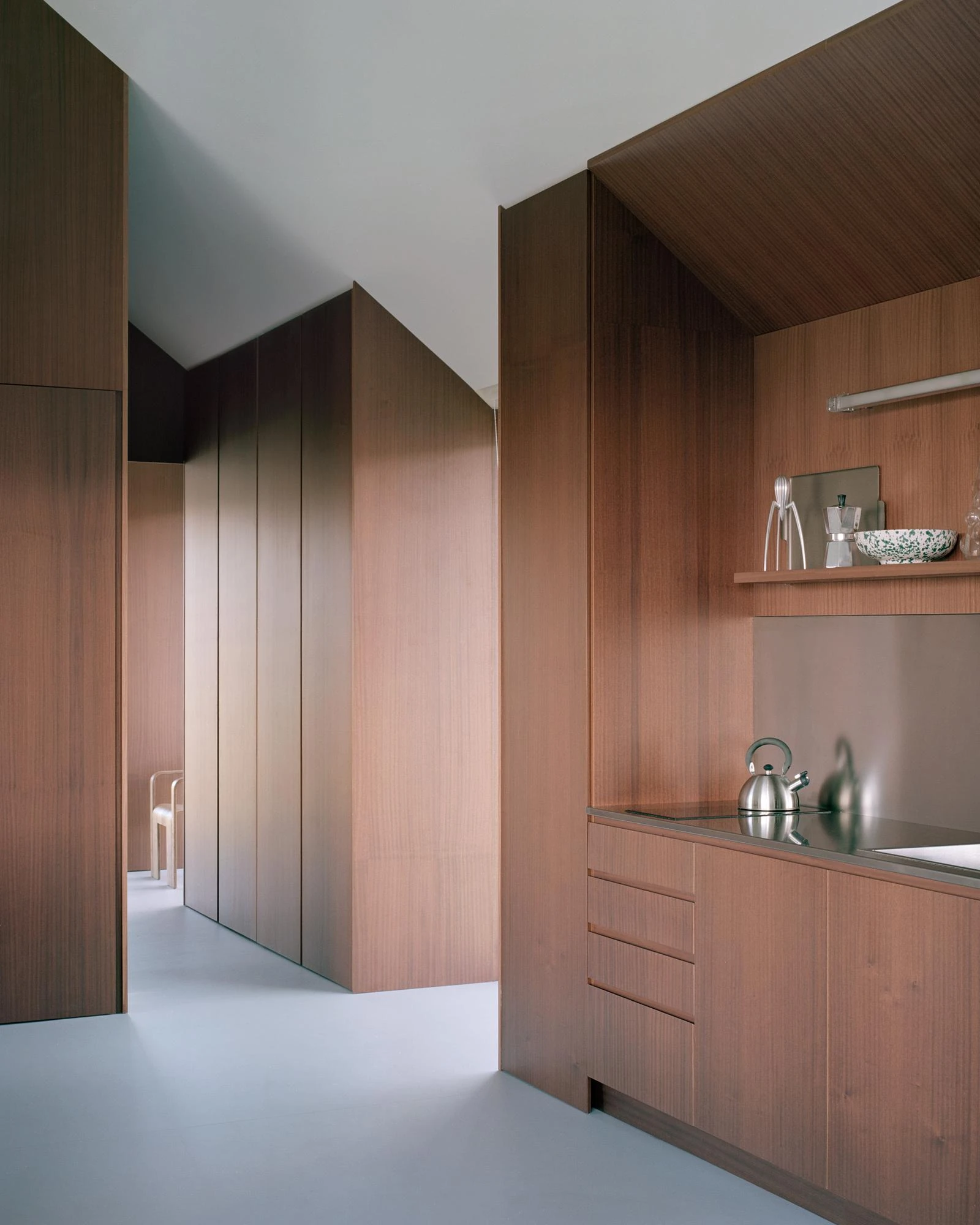 Casa Guadalupe by HANGHAR, photographed by Rory Gardiner — The kitchen built into freestanding sapele volumes with a stainless counter and a kettle.