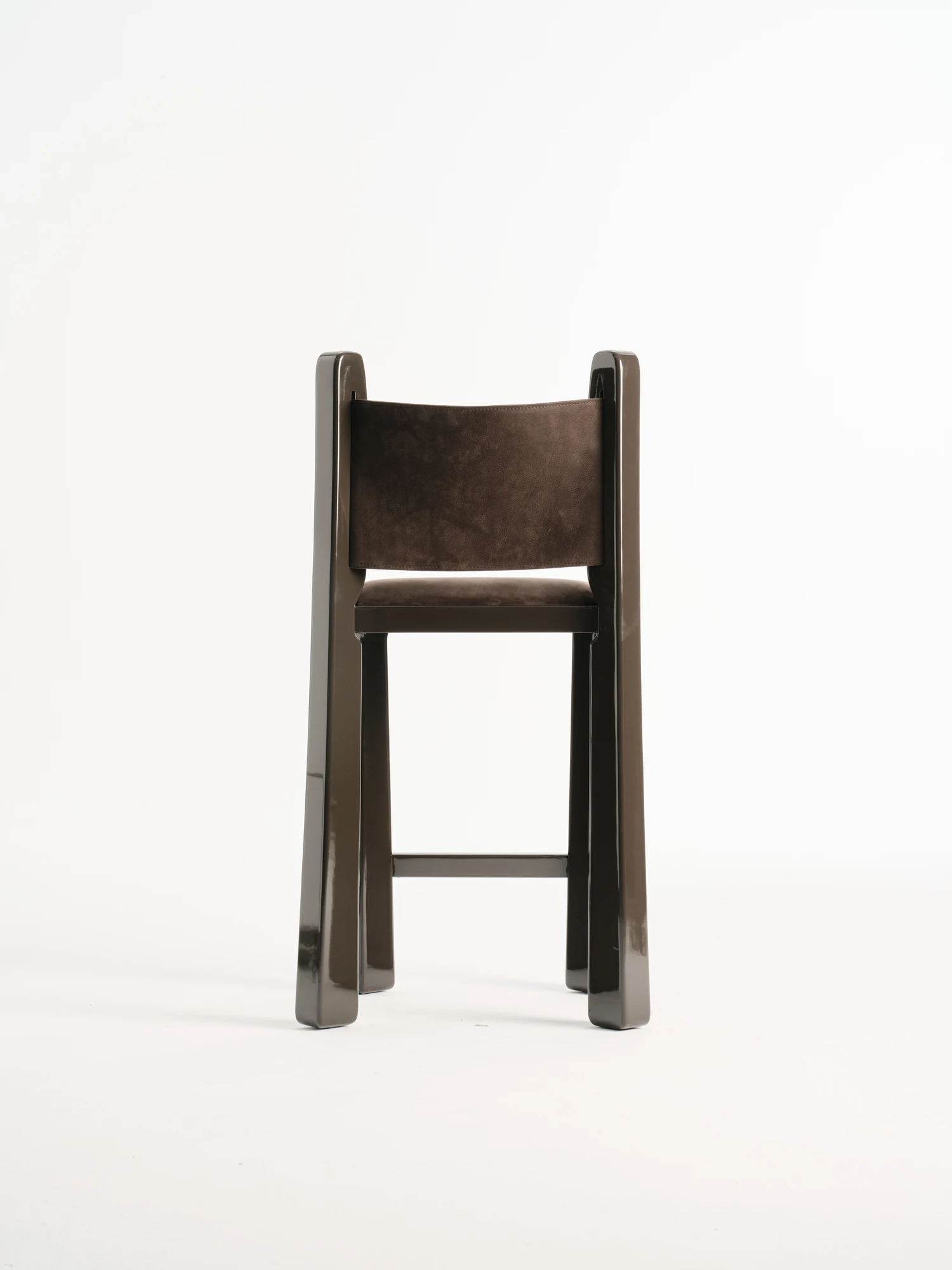 Ruby by NOVSEP, photographed by NOVSEP — Front view of a dark Ruby stool with a cognac suede seat and low back panel, isolated on white.