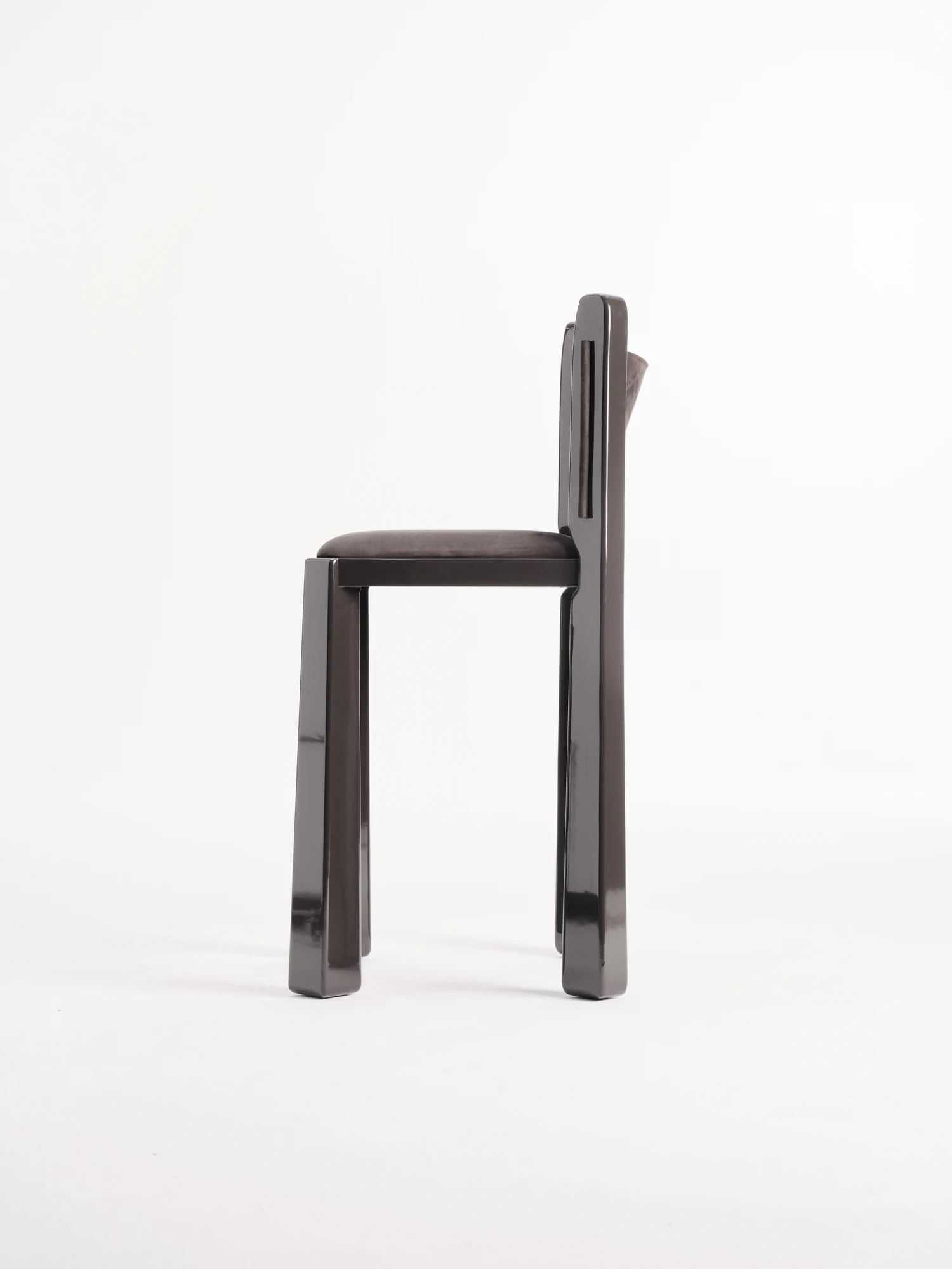 Ruby by NOVSEP, photographed by NOVSEP — Side profile of the espresso Ruby stool showing the splayed lacquer frame, the footrest bar and the leather back slung between the uprights.