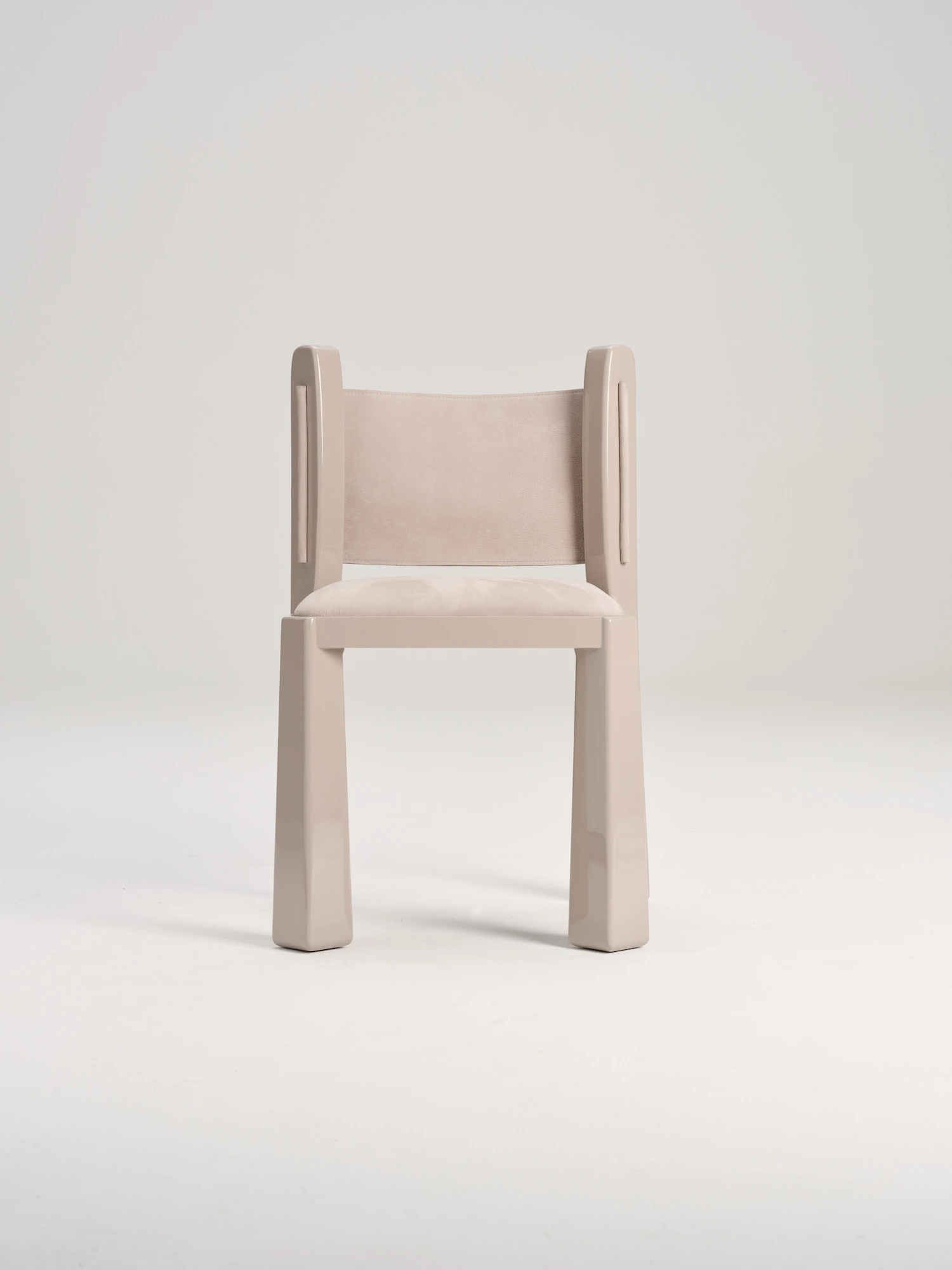 Ruby by NOVSEP, photographed by NOVSEP — The greige Ruby chair in three-quarter view, the suede back panel slung between the two rear stiles.