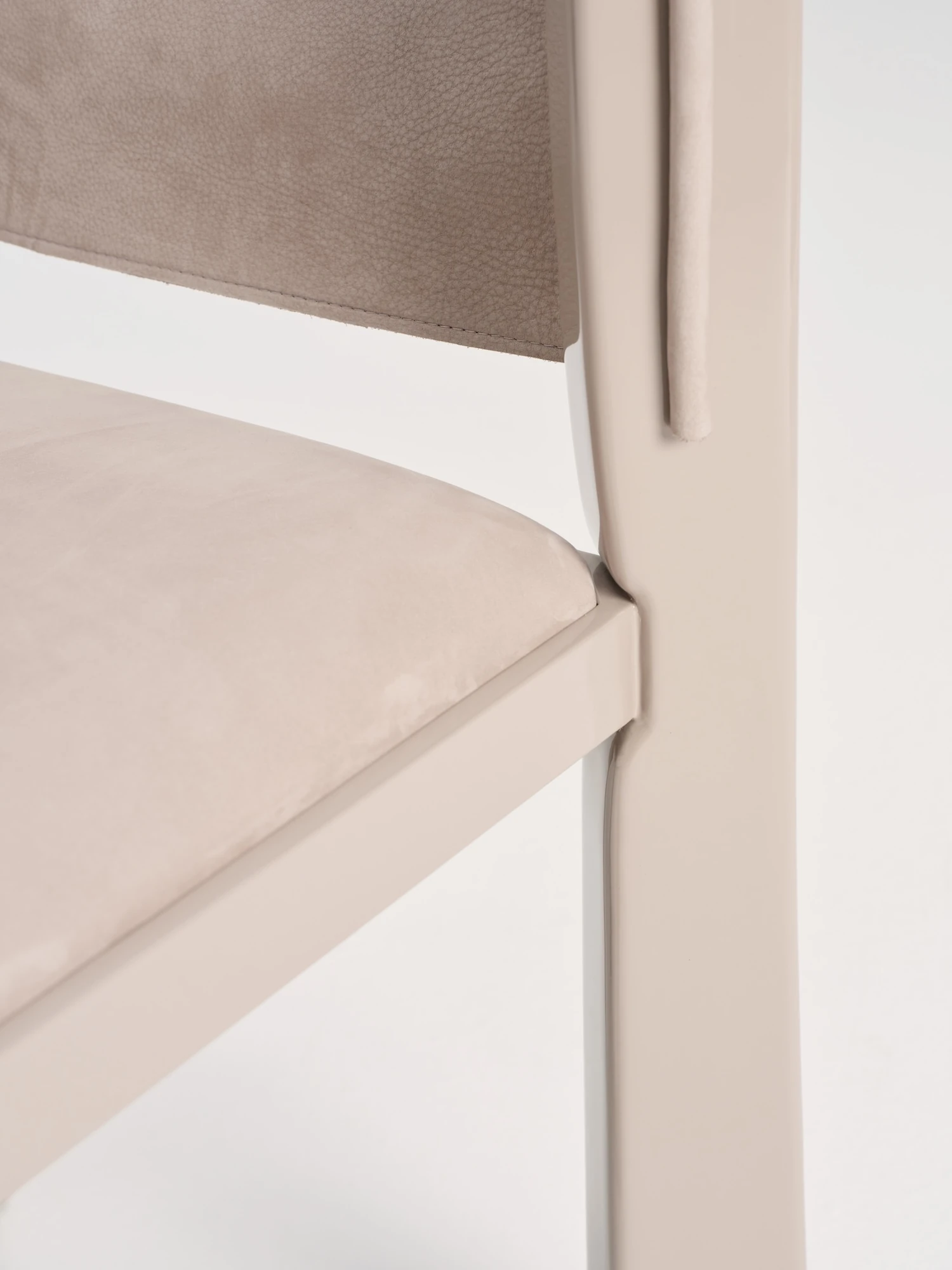 Ruby by NOVSEP, photographed by NOVSEP — Detail of the junction between the suede back and the seat, the lacquered stile passing behind the upholstery.