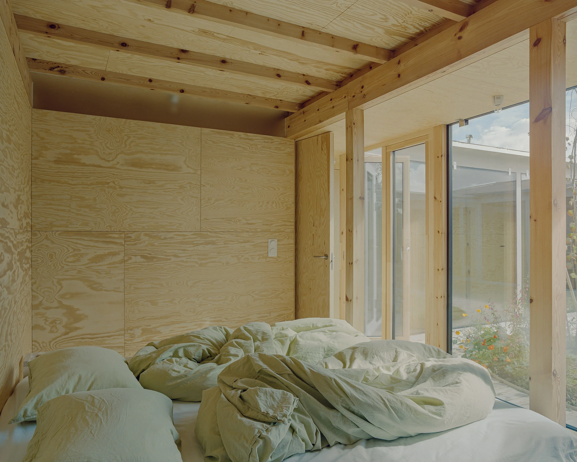 Ersland & Skeie House by Knut Hjeltnes Architects, photographed by Hugo Lütcherath — The square outdoor room opens onto the timber deck, the house almost entirely glazed toward it.