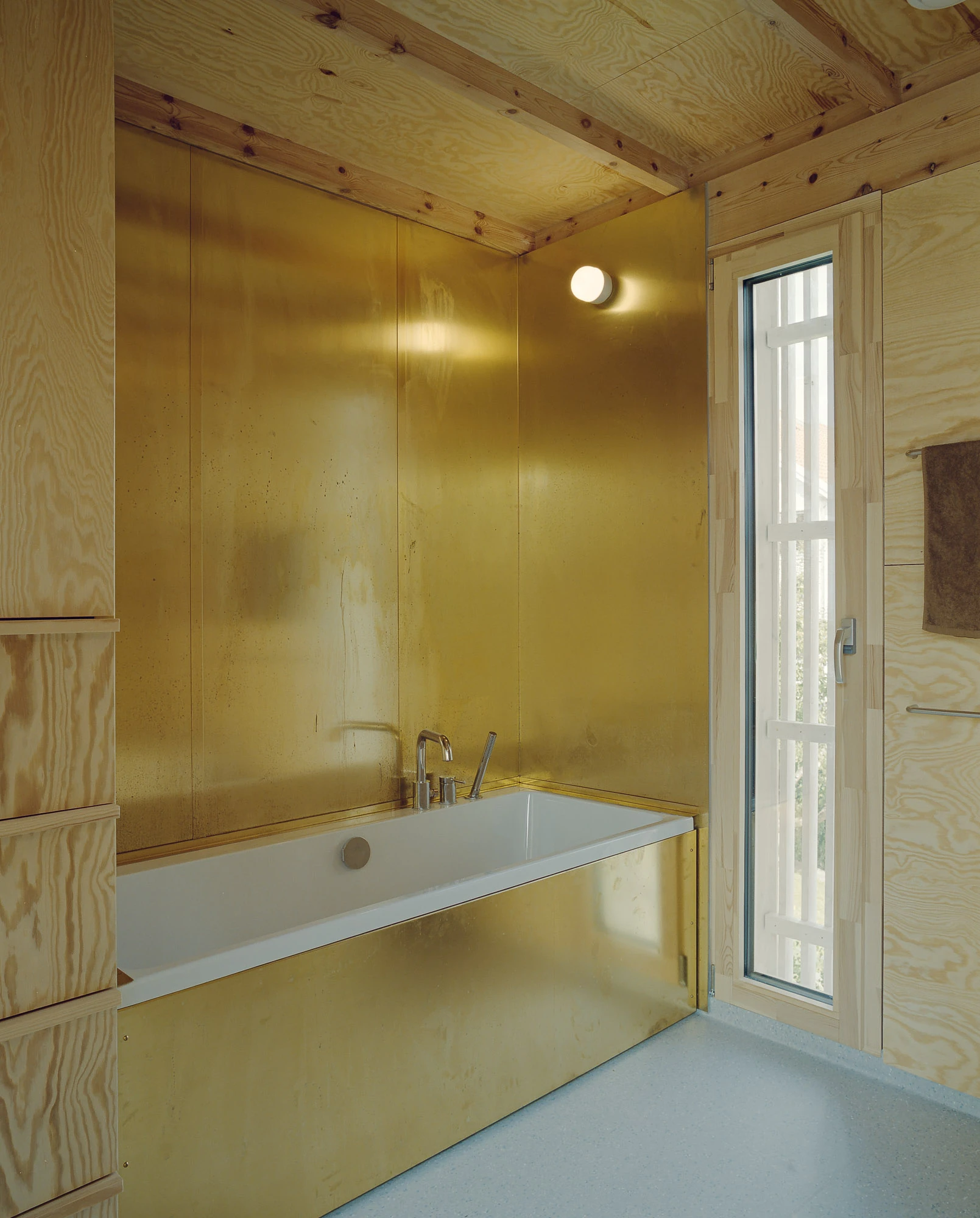 Ersland & Skeie House by Knut Hjeltnes Architects, photographed by Hugo Lütcherath — Bespoke pine drawers and shelves line a dressing space beside a glazed door to the deck.