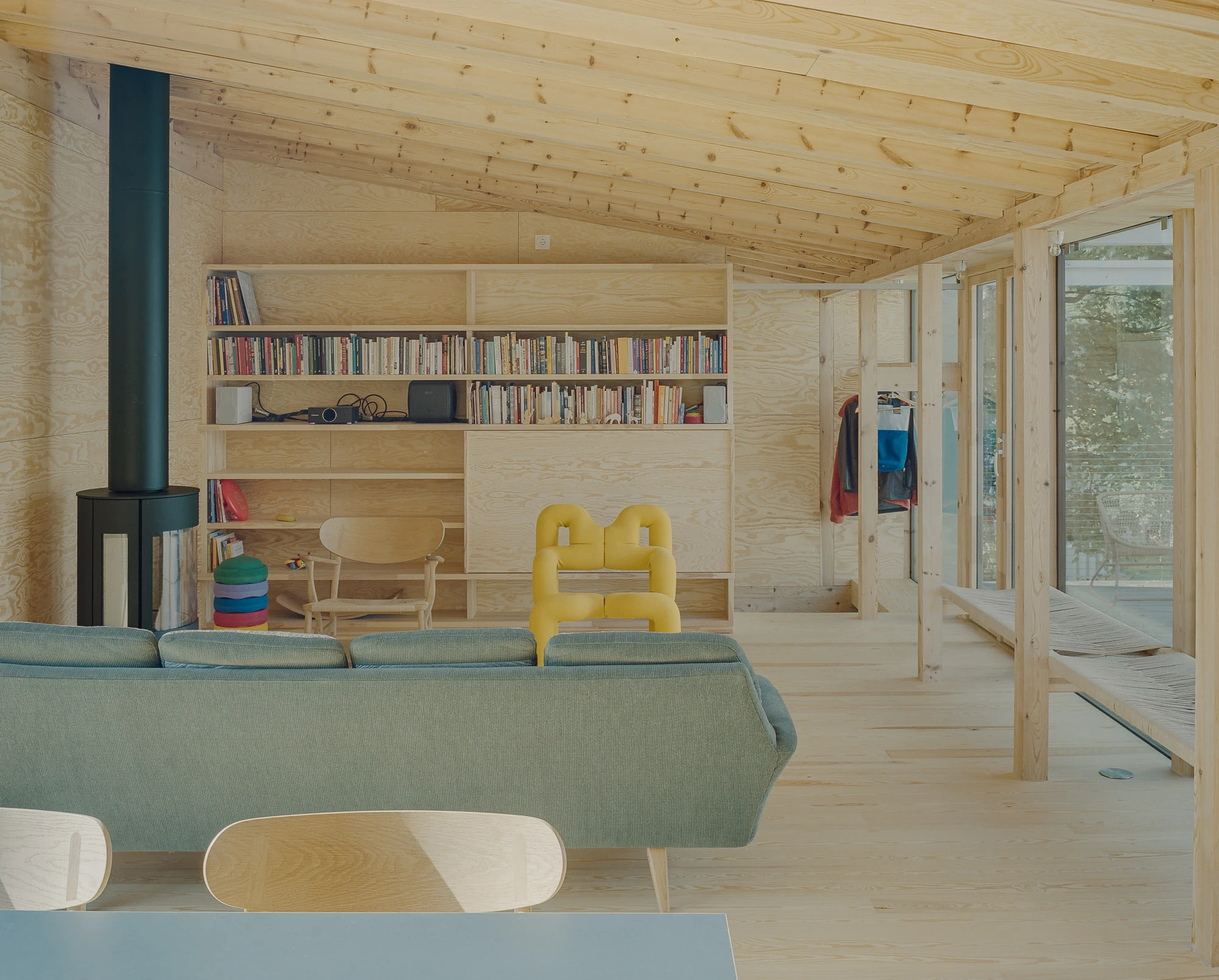 Ersland & Skeie House by Knut Hjeltnes Architects, photographed by Hugo Lütcherath — A detail of the woven rope bench and its pine frame on the pale pine floor.