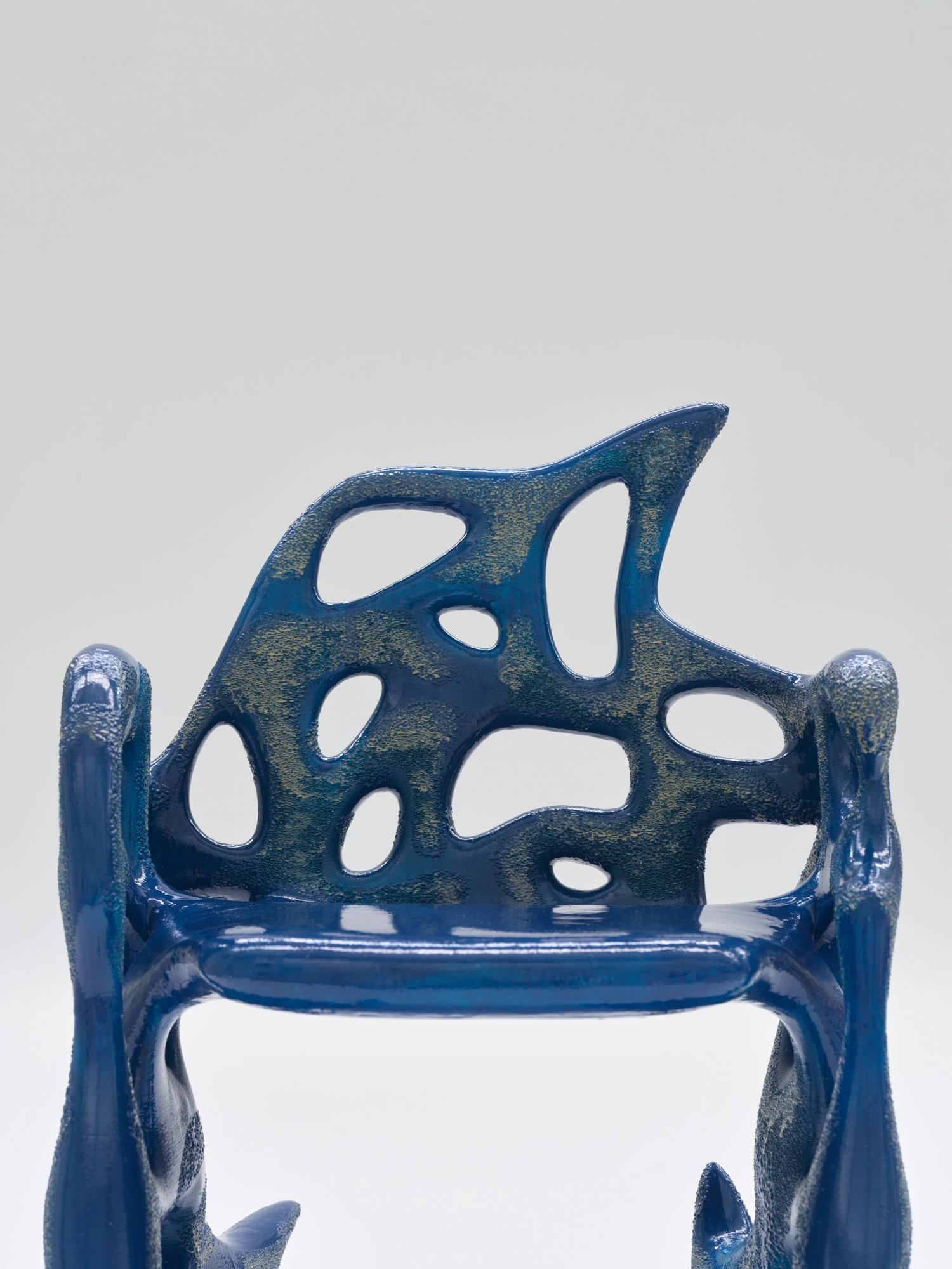 Extrude, Bridge, Fill by Lasse Sylvest Lilleør, photographed by Robert Damisch — Detail of the Sleigh Chair's back, cobalt gloss over a granular, speckled surface.