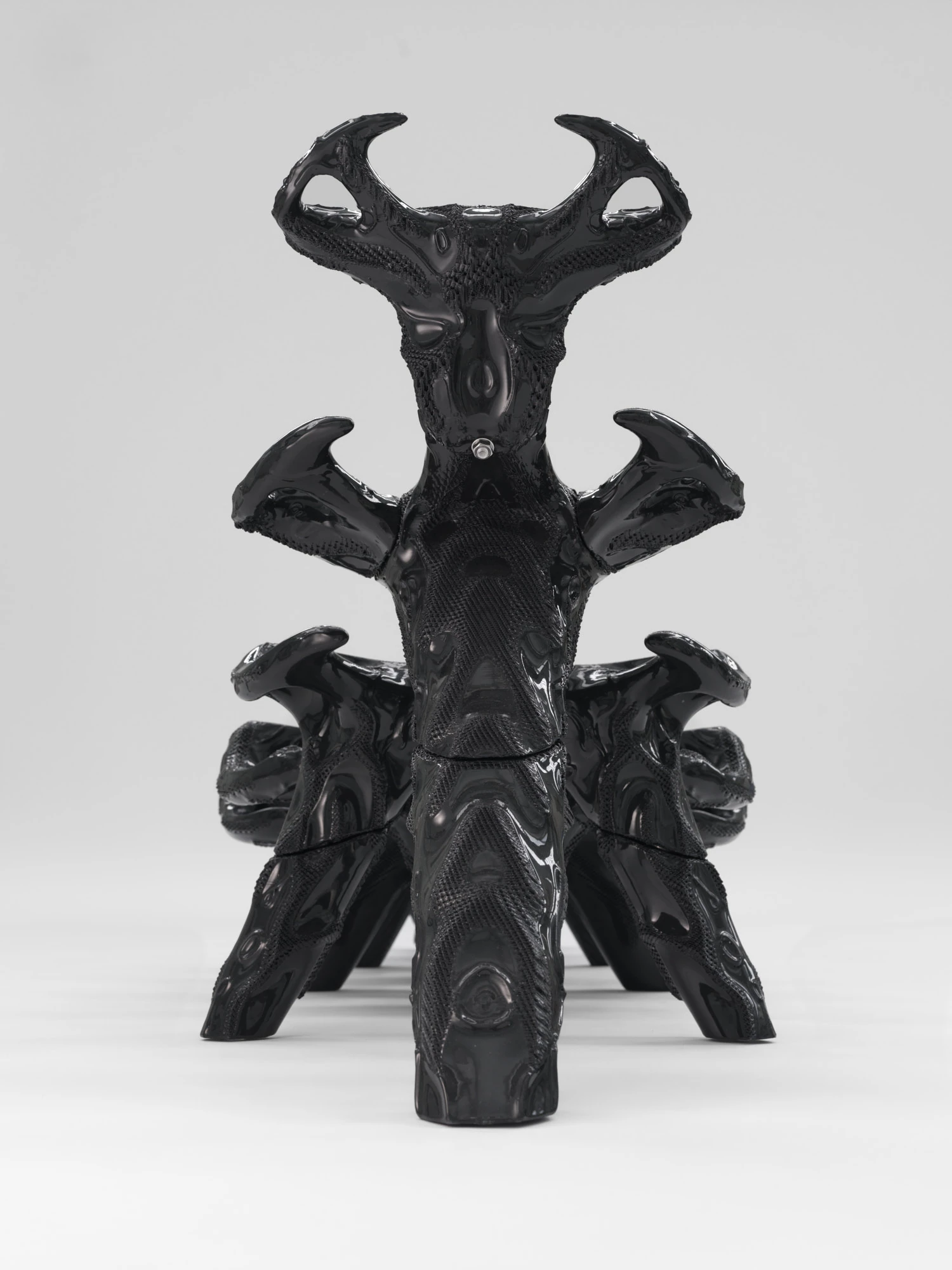 Extrude, Bridge, Fill by Lasse Sylvest Lilleør, photographed by Robert Damisch — The Dazing Devil lounger in ASA and bolts, a glossy black spinal column of stacked, horned vertebrae.