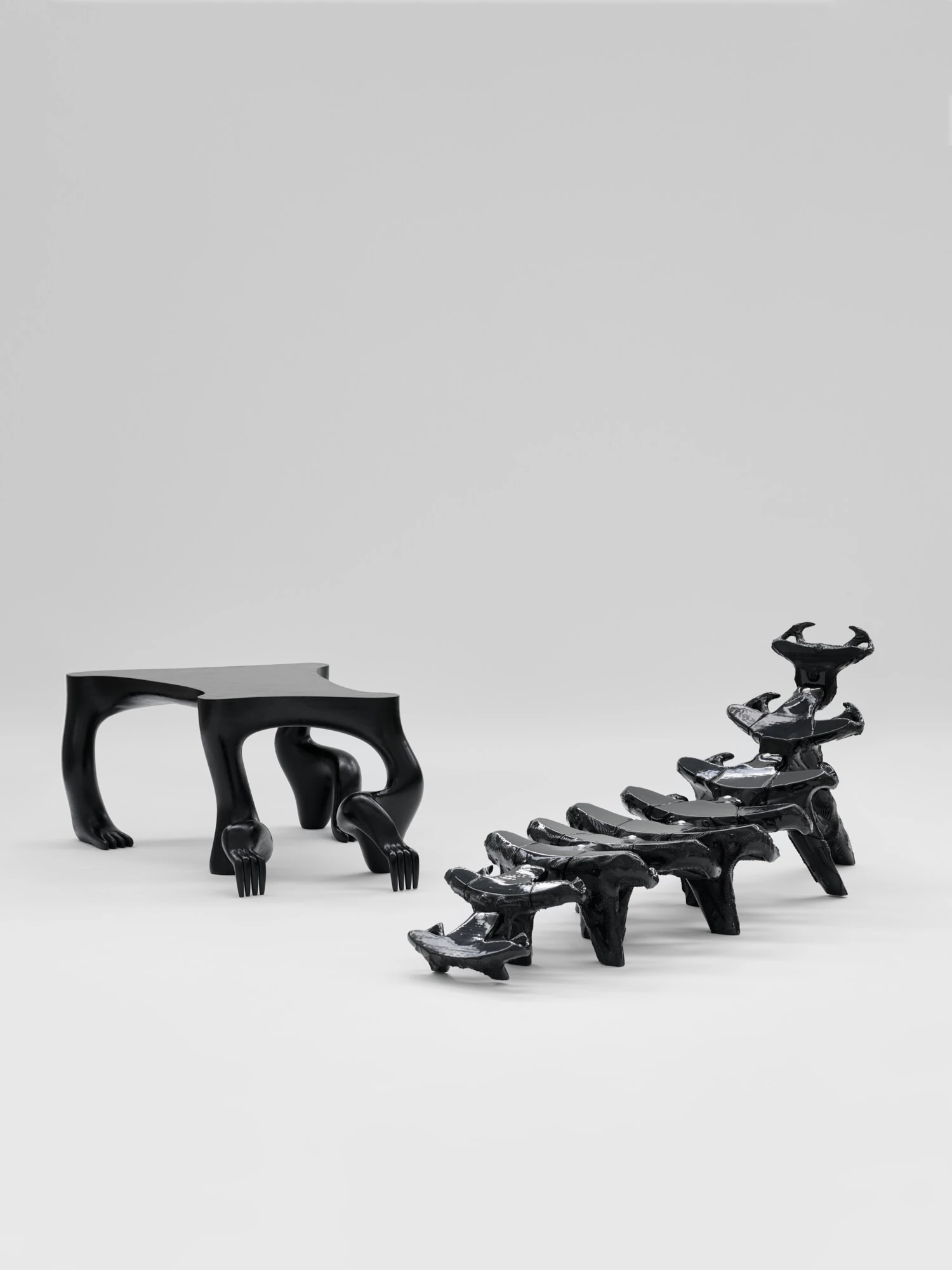 Extrude, Bridge, Fill by Lasse Sylvest Lilleør, photographed by Robert Damisch — The Crawler Coffee Table and the Dazing Devil lounger shown together, black forms on a grey ground.