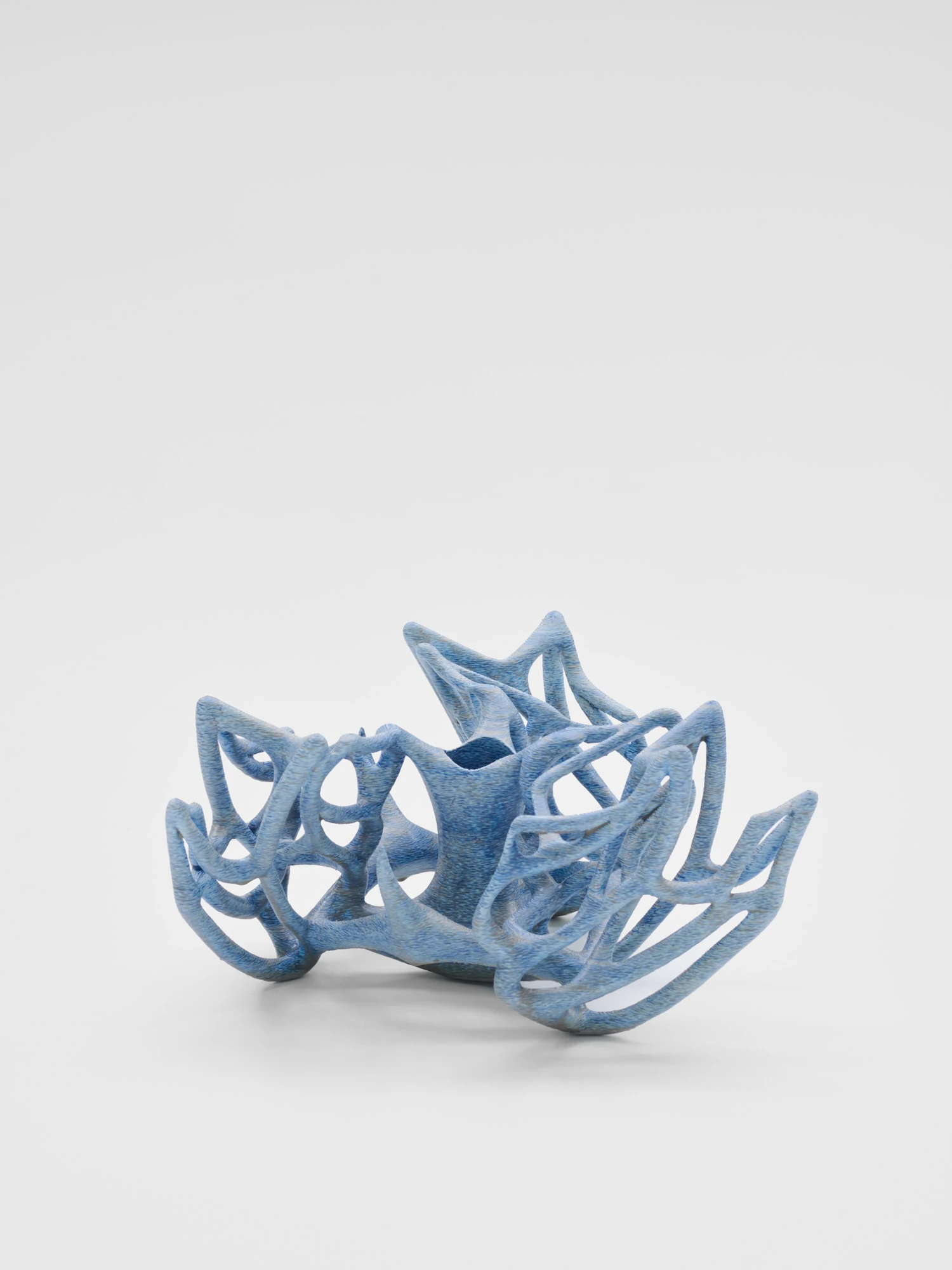 Extrude, Bridge, Fill by Lasse Sylvest Lilleør, photographed by Robert Damisch — A pale blue rib vase opening like a star, its filaments curling around a central well.