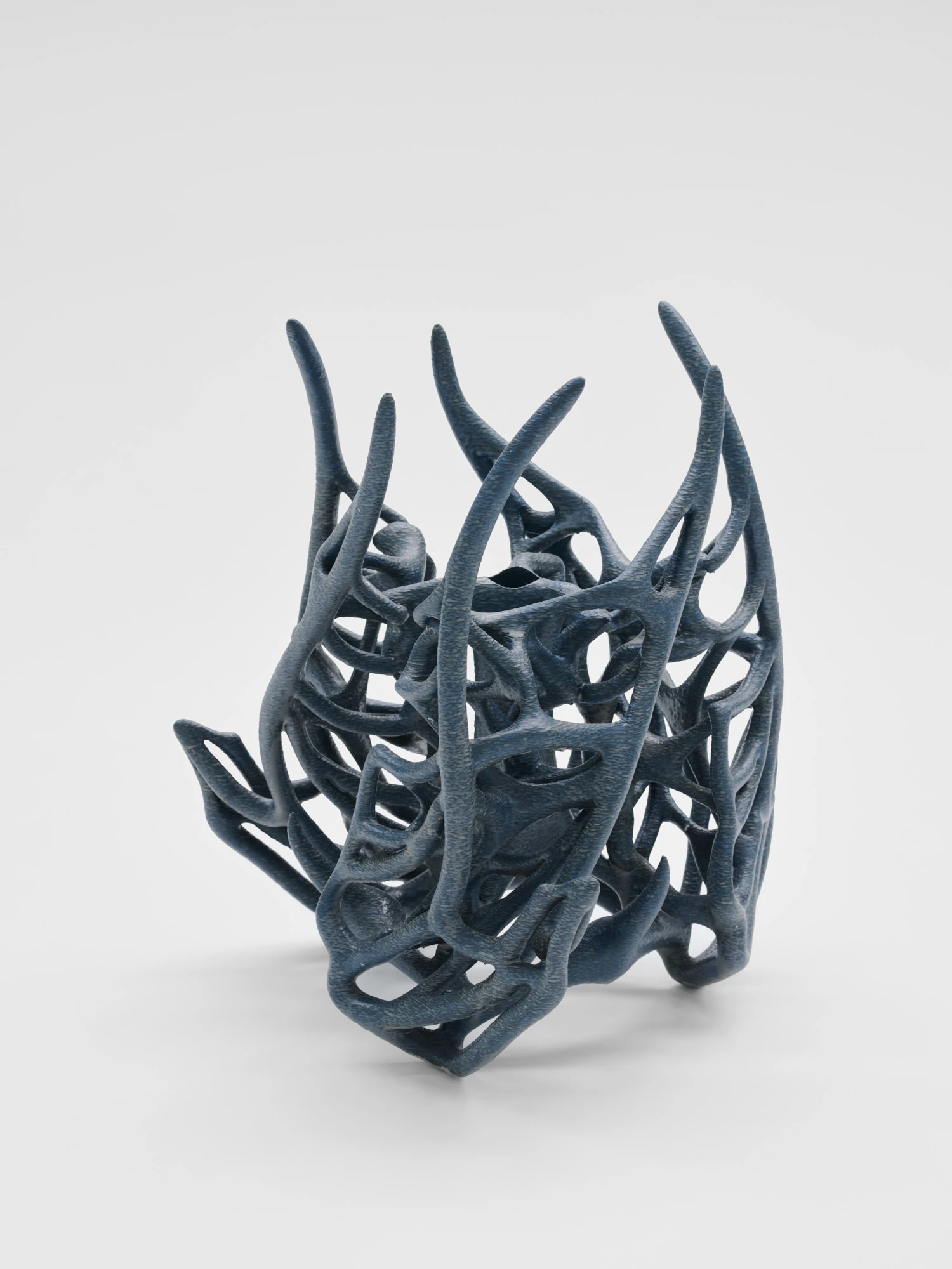 Extrude, Bridge, Fill by Lasse Sylvest Lilleør, photographed by Robert Damisch — A navy radiated rib vase, its thorned lattice rising into open spikes, printed in PLA, resin and dye.