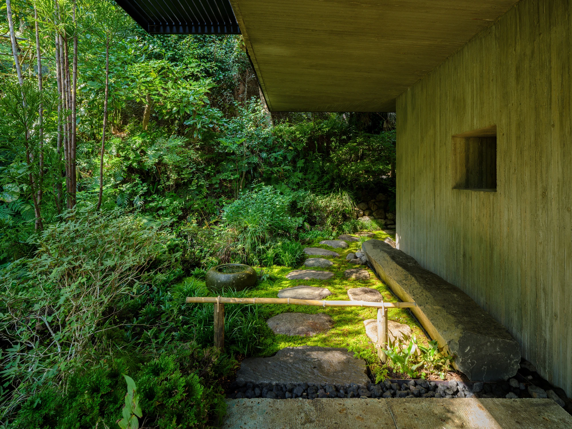 Konkuri-an by Teitakusubako, Yusuke Igarashi Architects, photographed by Kentaro Nemoto, Kazumasa Harada — The washed concrete teahouse set into its Kamakura valley, moss and stone gathering at the base of the wall.