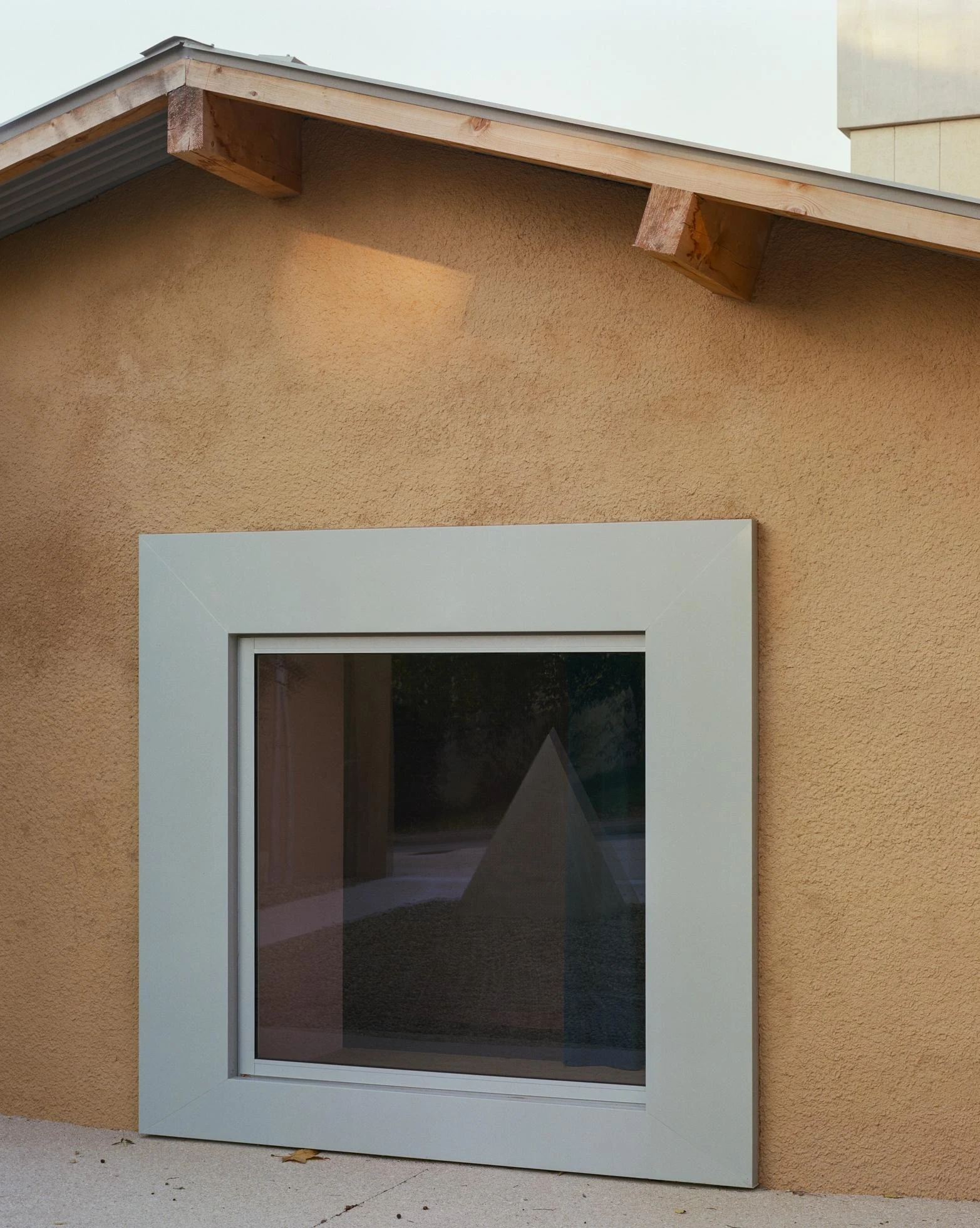 Cultural and Community Center, Coudoux by atelier EGR, photographed by Giaime Meloni — A square window is set into the wall of the rehabilitated sheepfold below its roof.