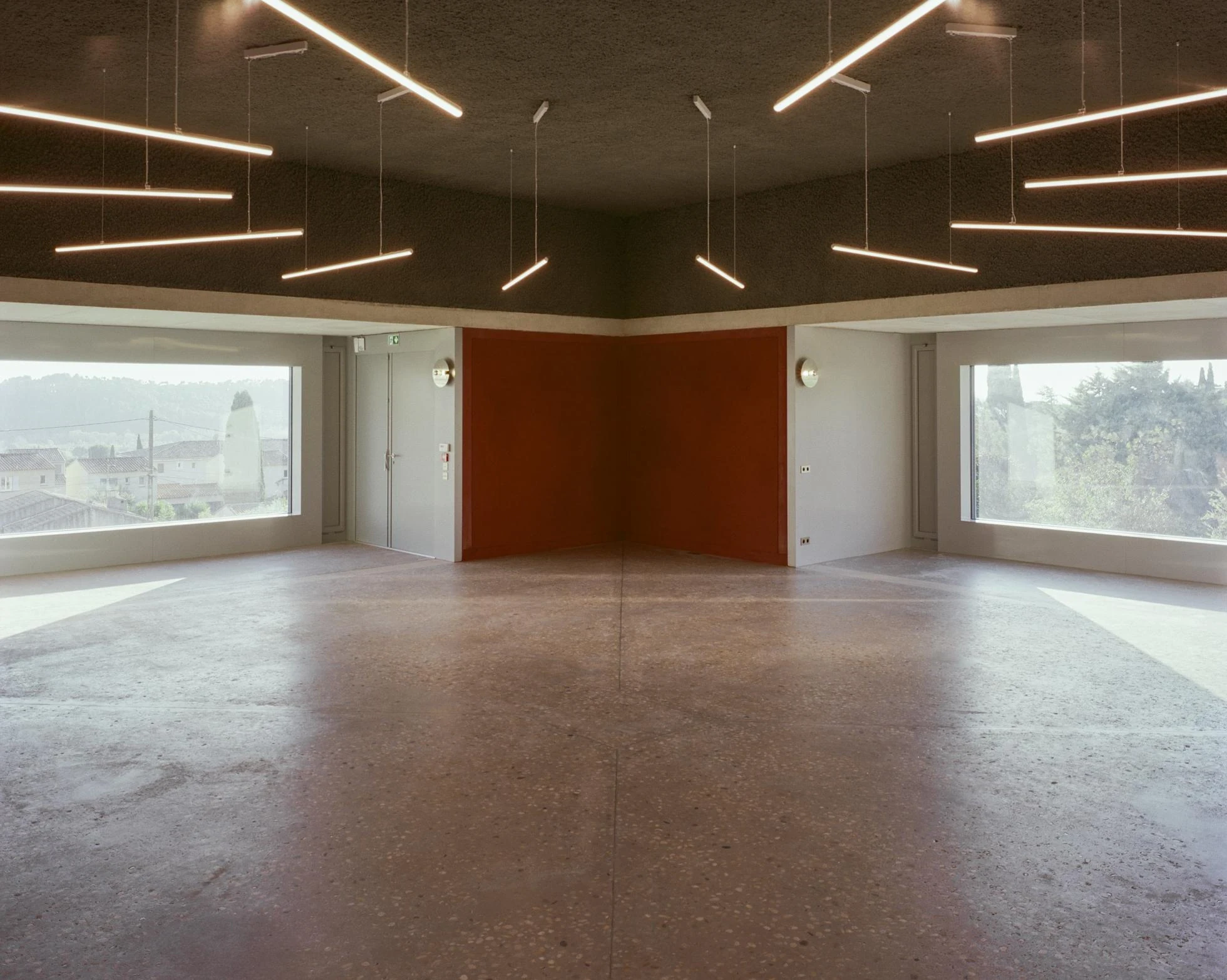 Cultural and Community Center, Coudoux by atelier EGR, photographed by Giaime Meloni — In the large upper room, deep framed windows open to the landscape on more than one side.