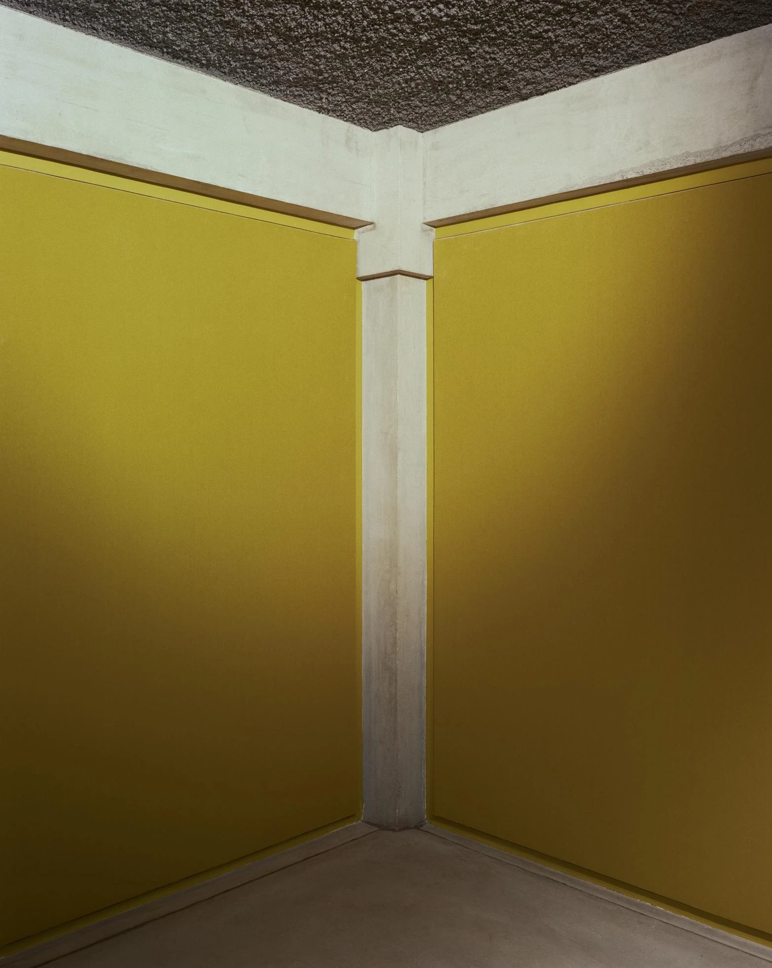 Cultural and Community Center, Coudoux by atelier EGR, photographed by Giaime Meloni — Two walls of yellow acoustic fabric meet at the raw concrete of the central structure.
