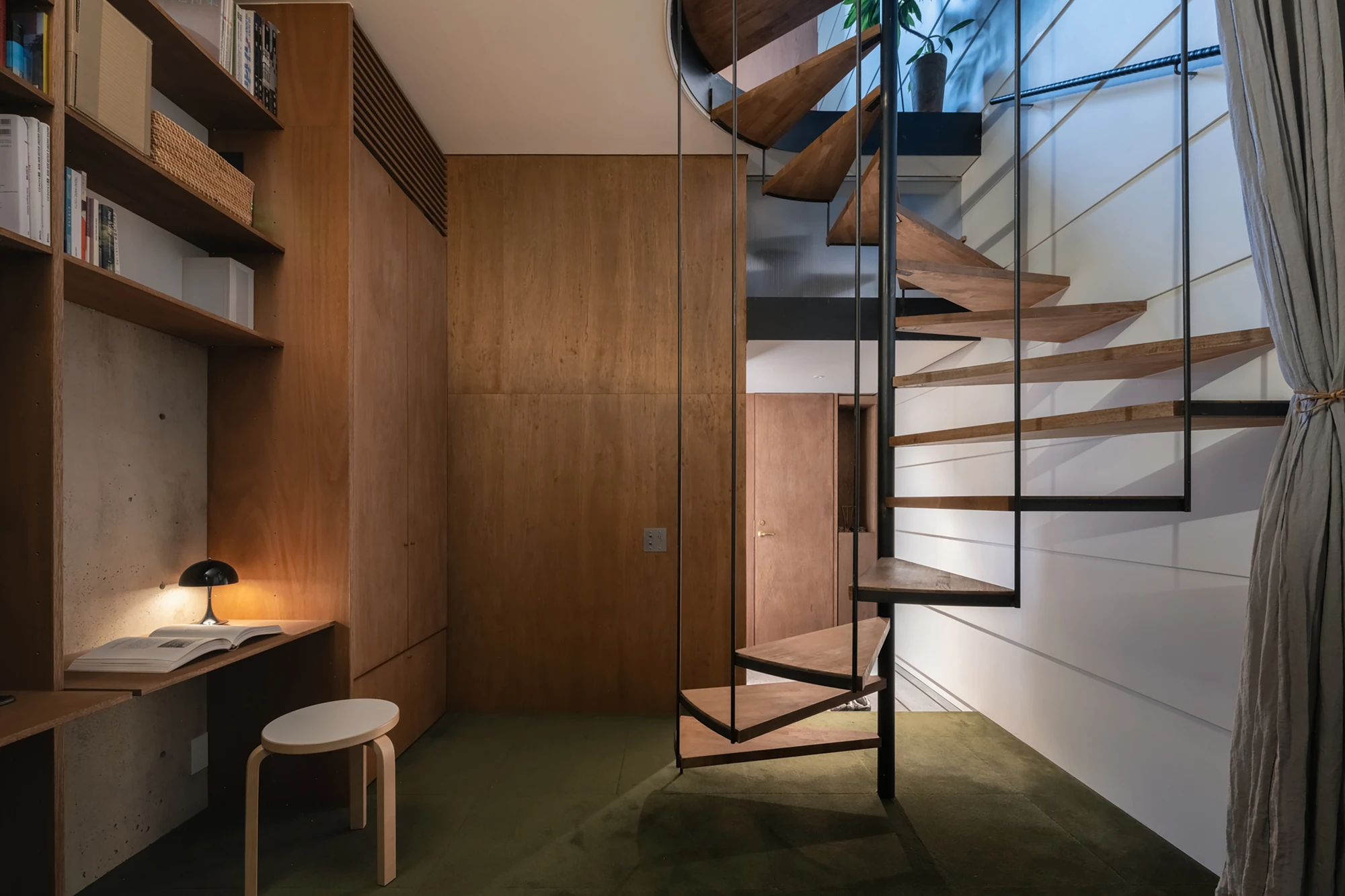House in Kagurazaka by Takumi Wakui + Riho Wakui Architects — A built-in desk and shelves sit against the central double wall, the timber stair descending alongside a private upper floor.